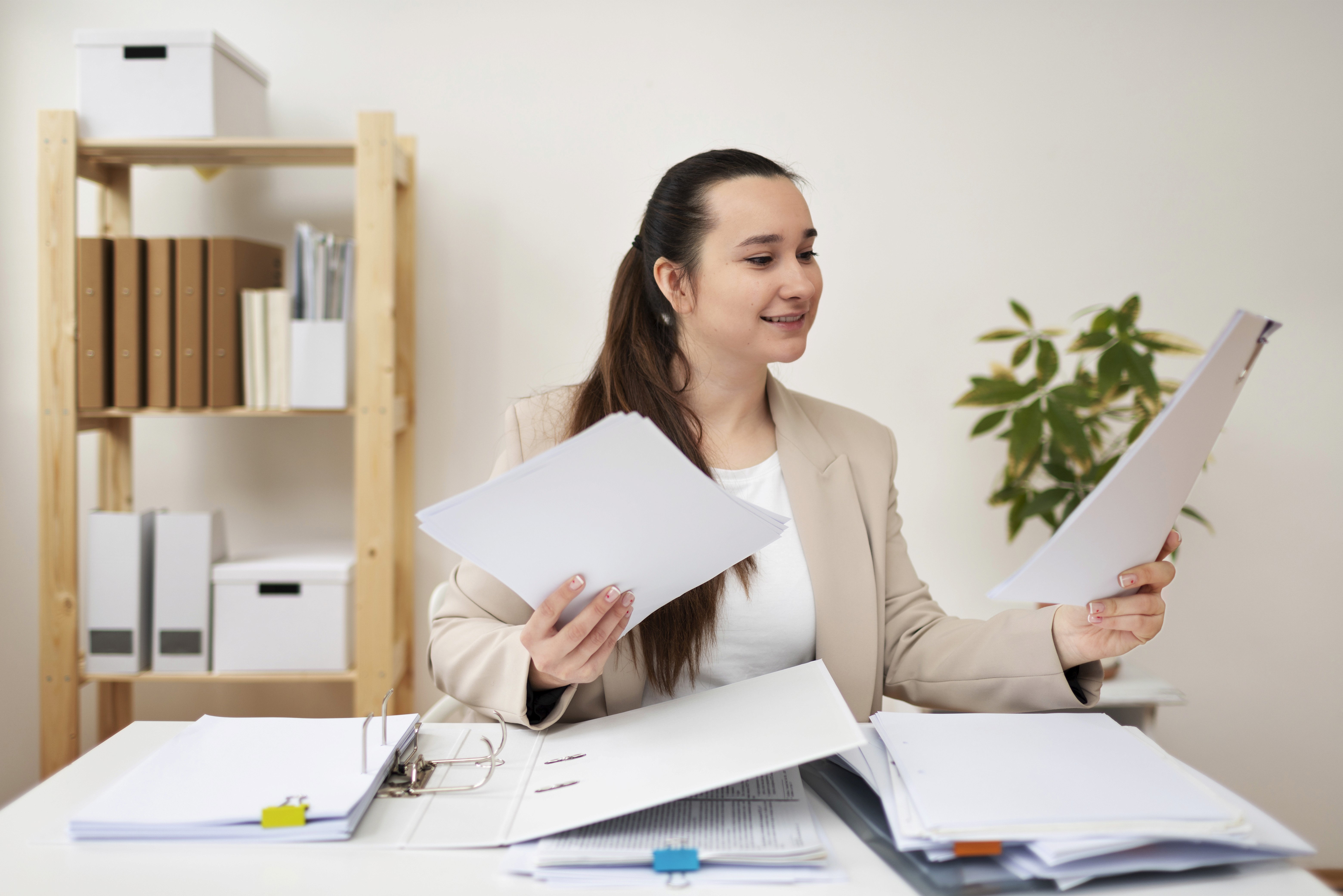 A young woman smiling as she organizes all the required documents for her UAE Green Visa Application.