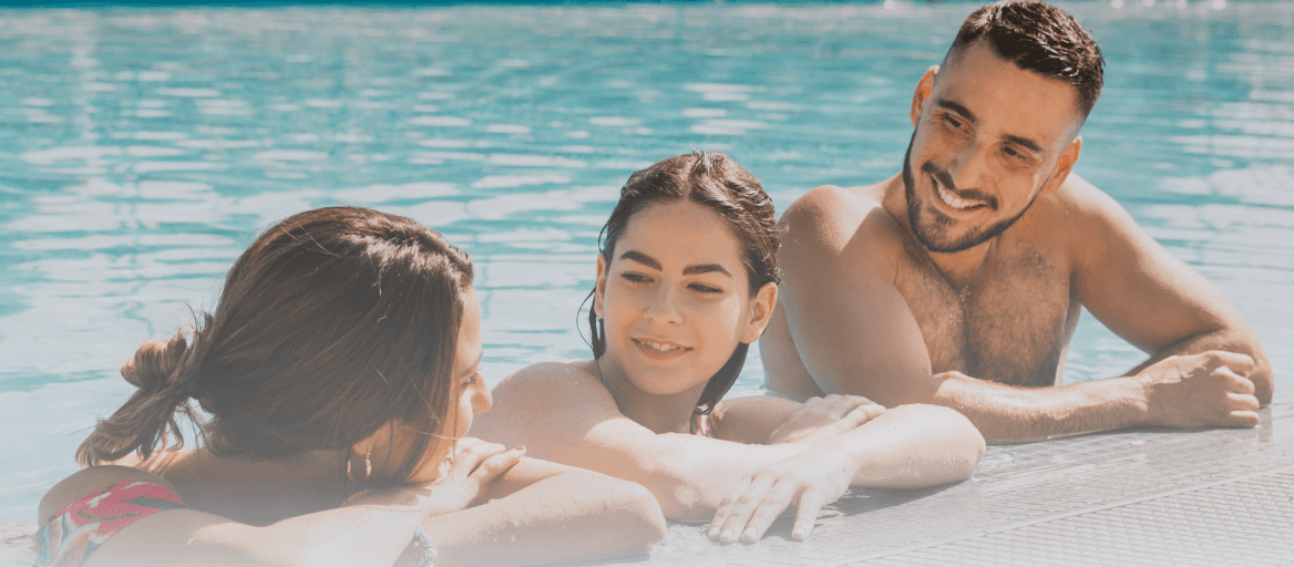 A family relaxing together in a swimming pool, enjoying warm water.