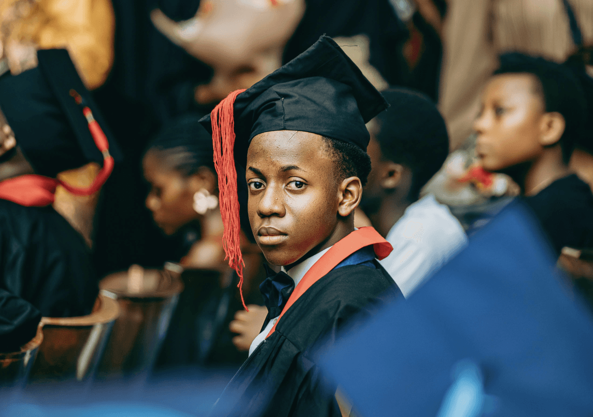 A softly lit hallway with a series of arched doorways, warm-toned walls, and wood flooring leading toward a seating area with neutral furniture.