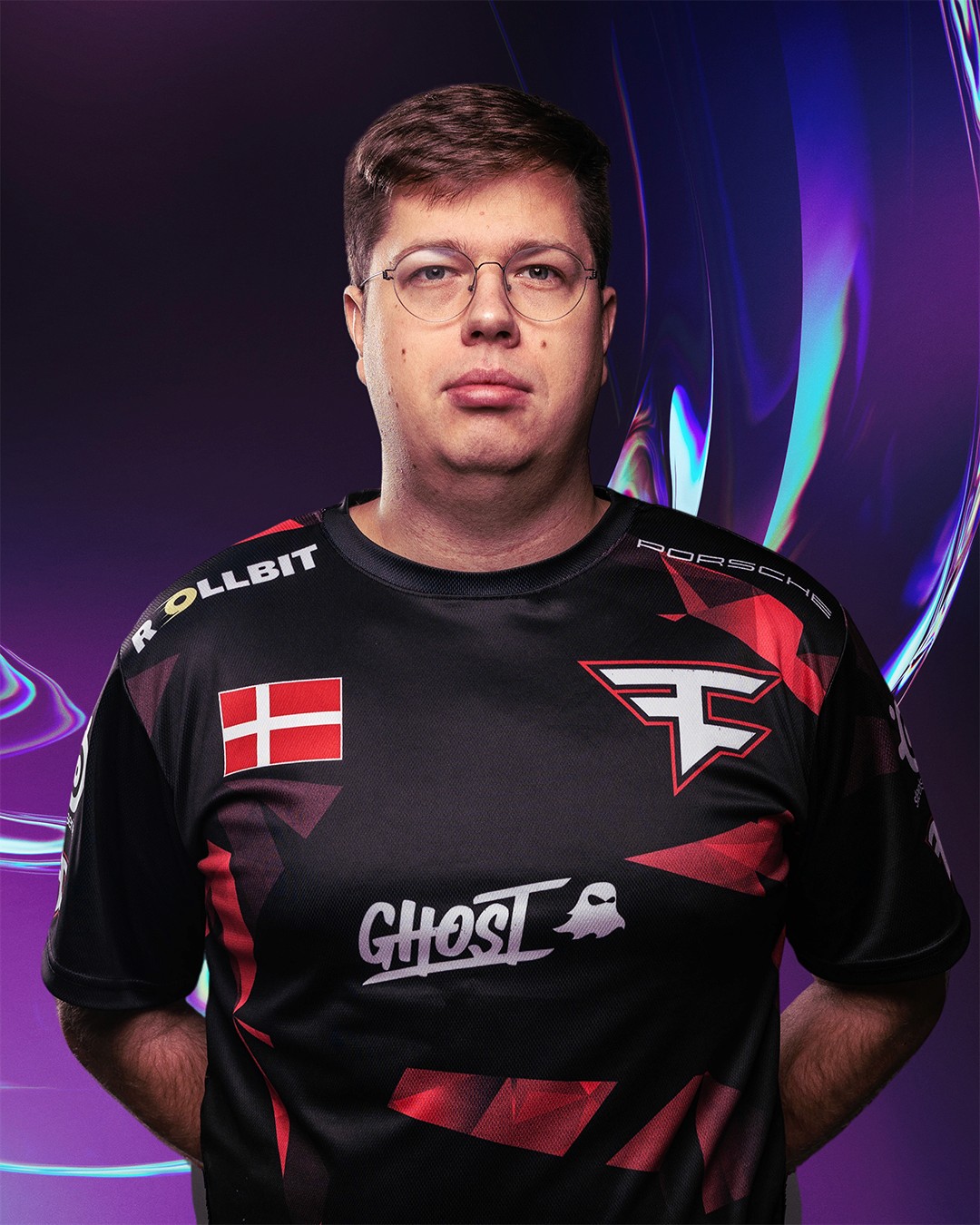 Portrait of a woman with long, smooth hair swept to the side, in a dark t-shirt, on a plain background.