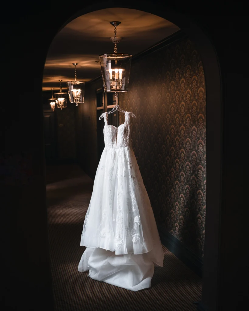 Wedding dress hanging in elegant hallway before Aspen Meadows Resort Wedding ceremony