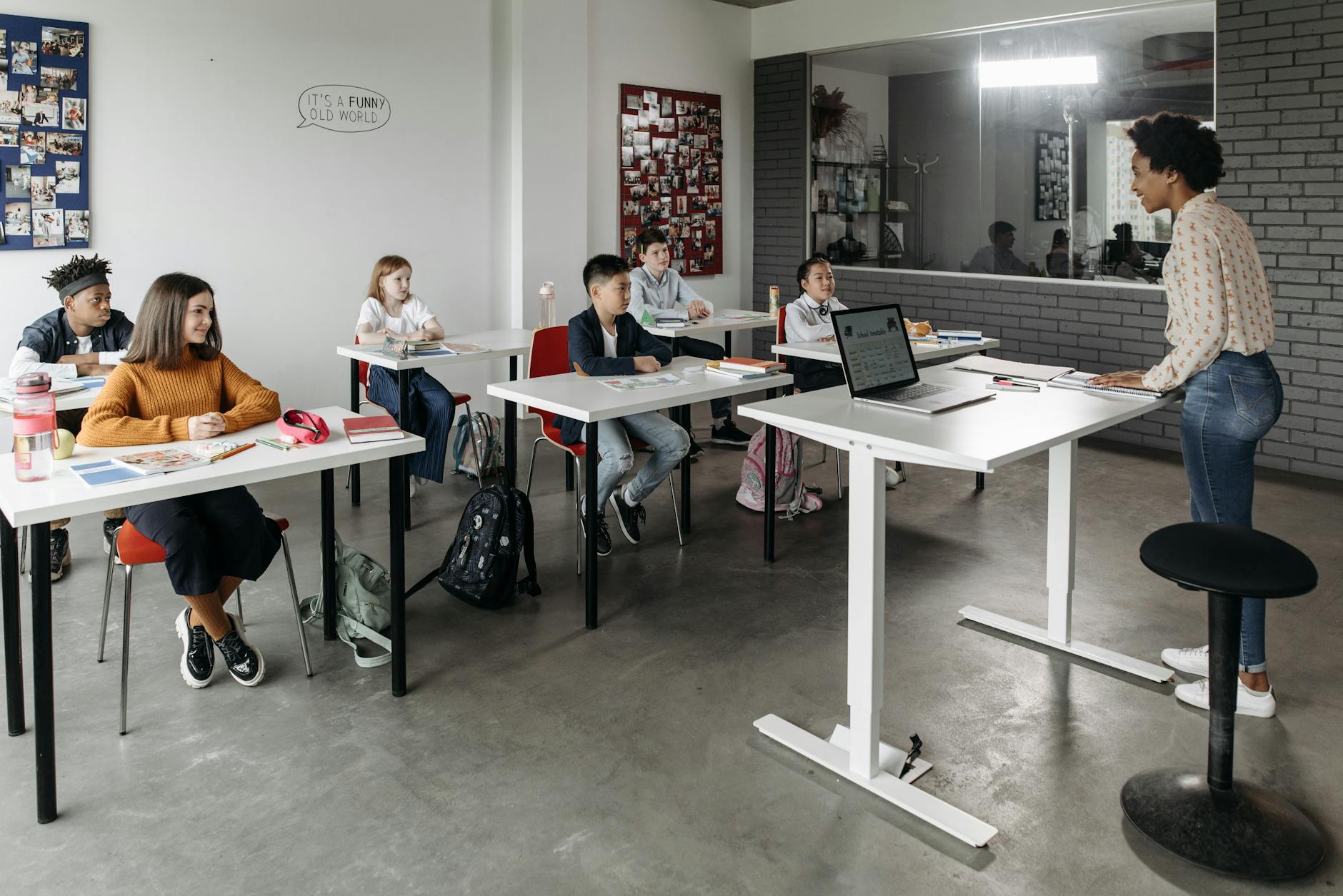 A smiling student with headphones works alongside peers in a bright general education classroom.