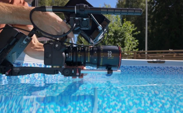 A cinema camera with a DZOFILM Arles zoom lens filming beside a swimming pool