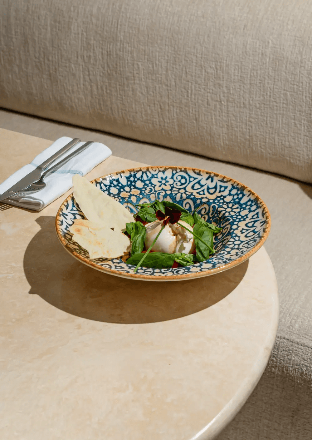 Burrata crémeuse servie avec roquette, tomates et pain pita
