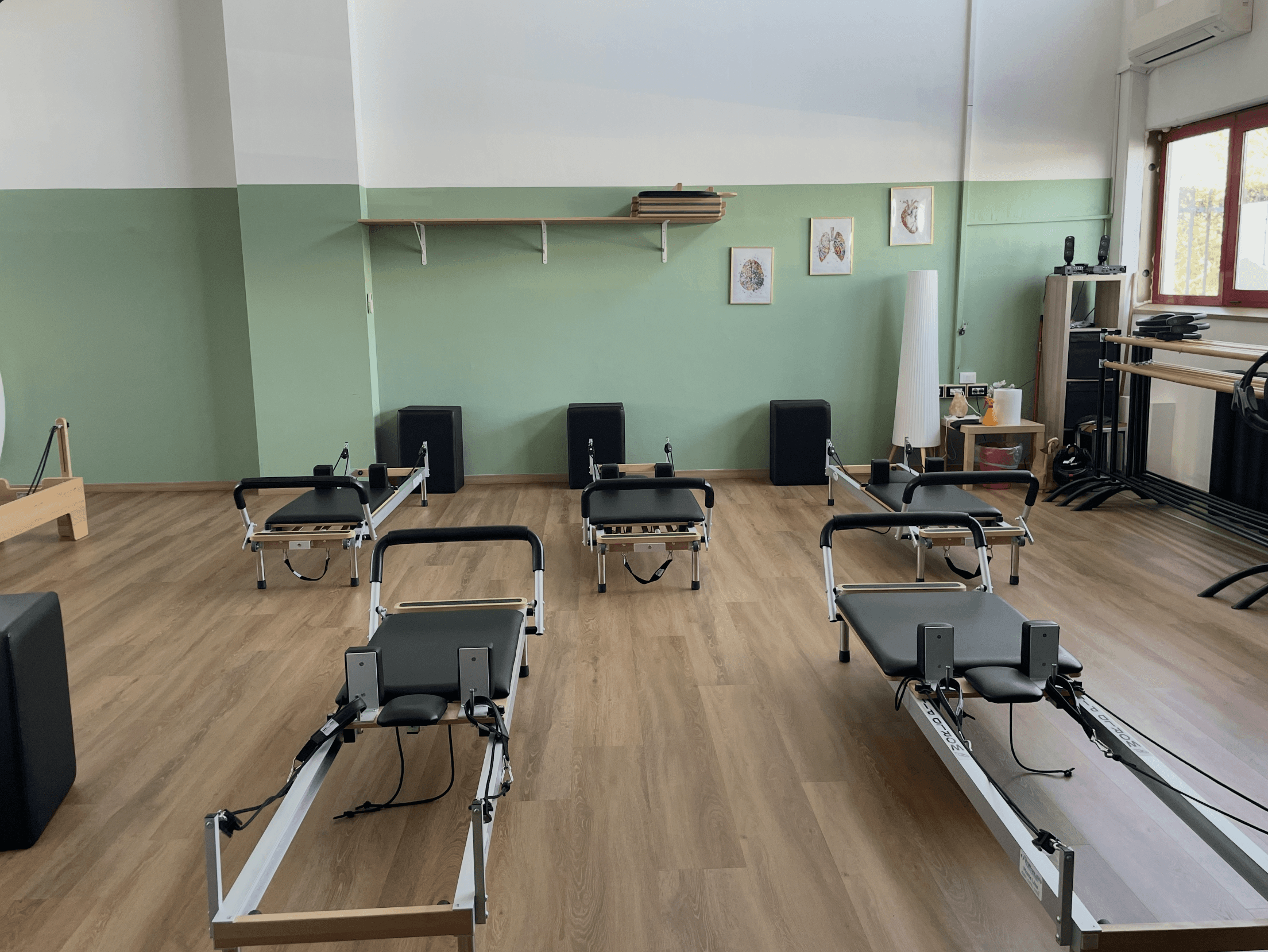 Panoramica dell'ambiente luminoso, pulito e professionale della sala Reformer all'interno dello Studio Pilates Pavia.