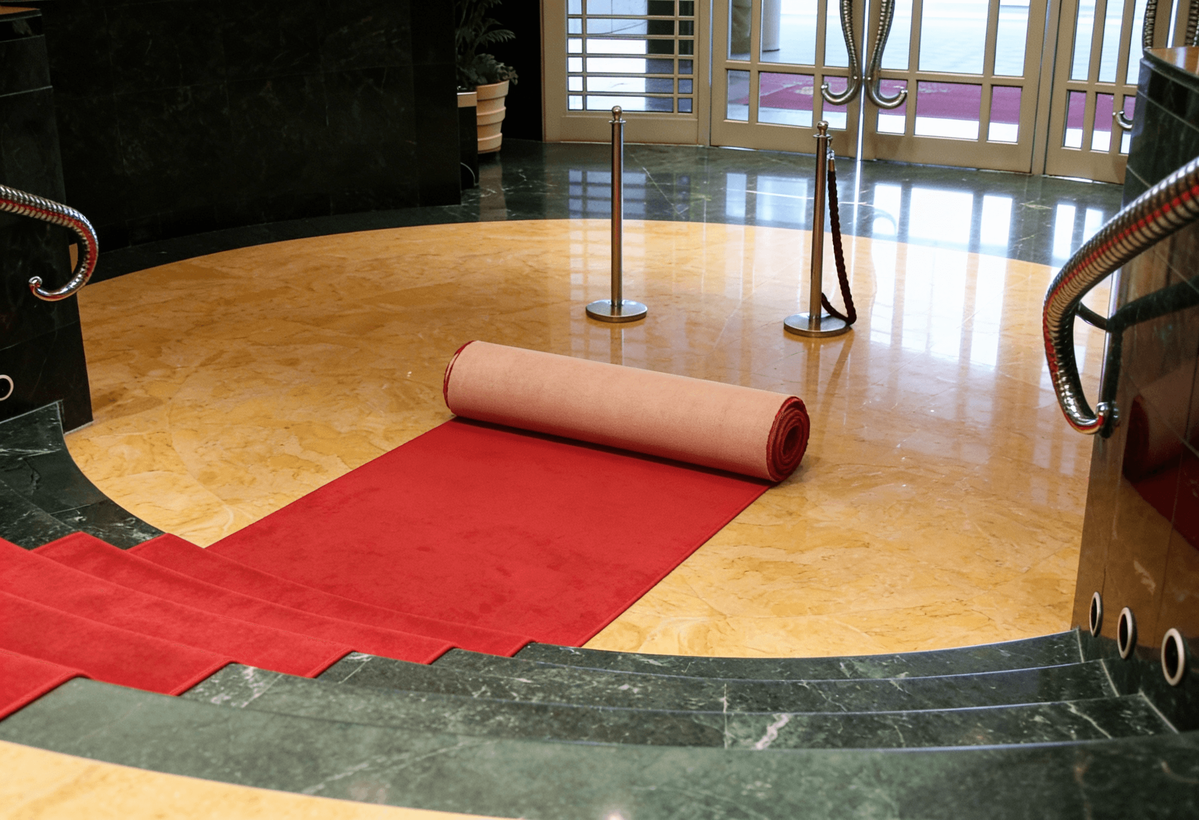Man wearing baseball hat and beige hoodie sitting on leather couch