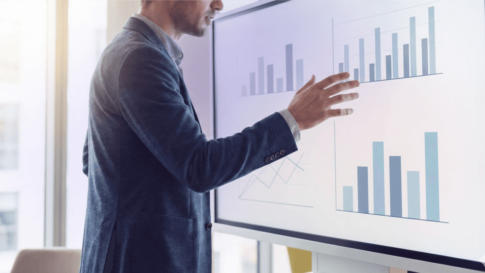 Executive at whiteboard reviewing company data.