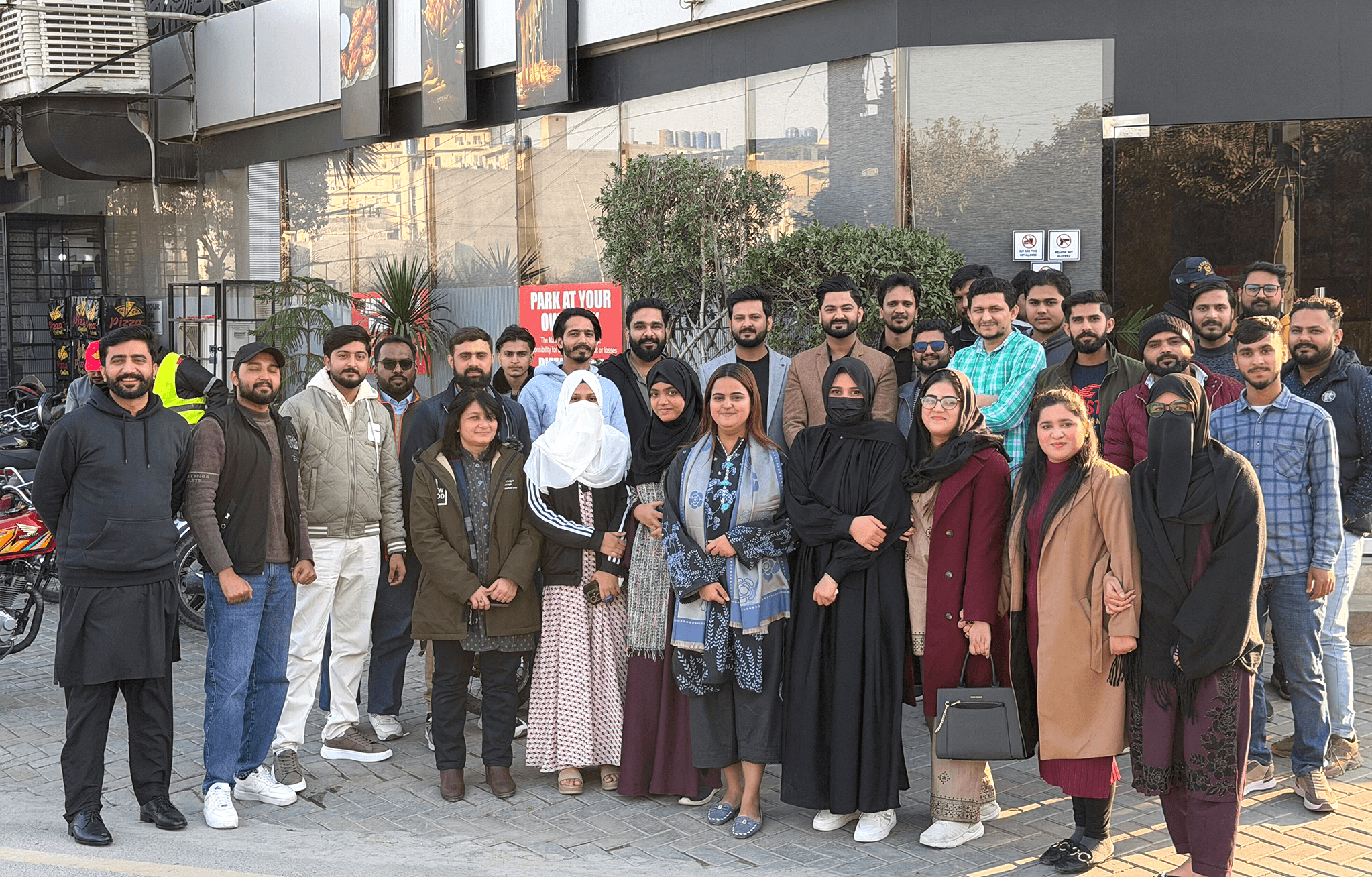 three men sitting while using laptops and watching man beside whiteboard