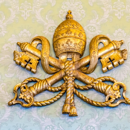 Golden papal tiara and crossed keys emblem on a pale green patterned background.