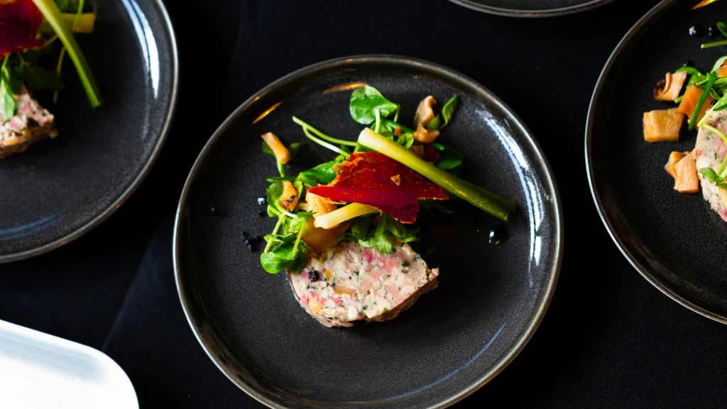 Overhead view of a chicken terrine starter with watercress and Parma ham