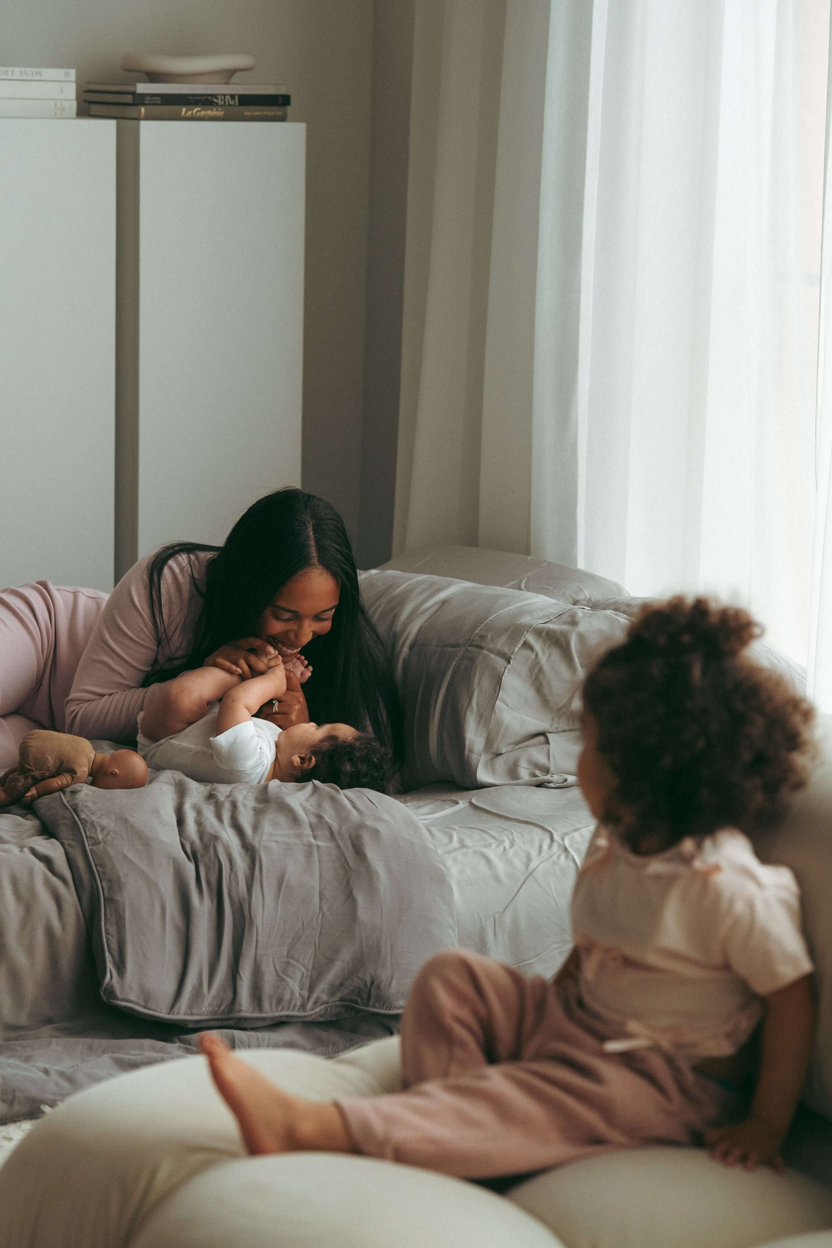 Une mère jouant avec ses jeunes enfants.
