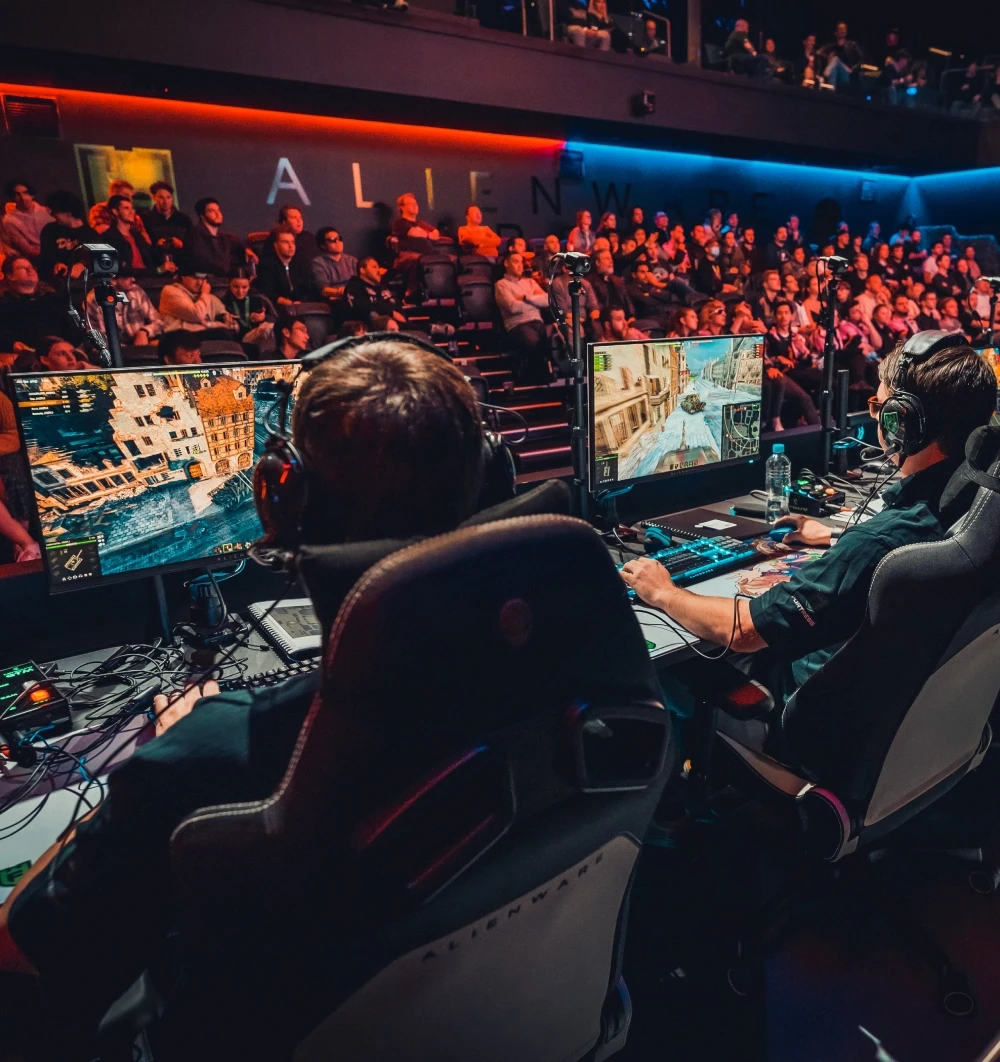 An esport arena with people sitting watching peoplep play games on computer at Fortress