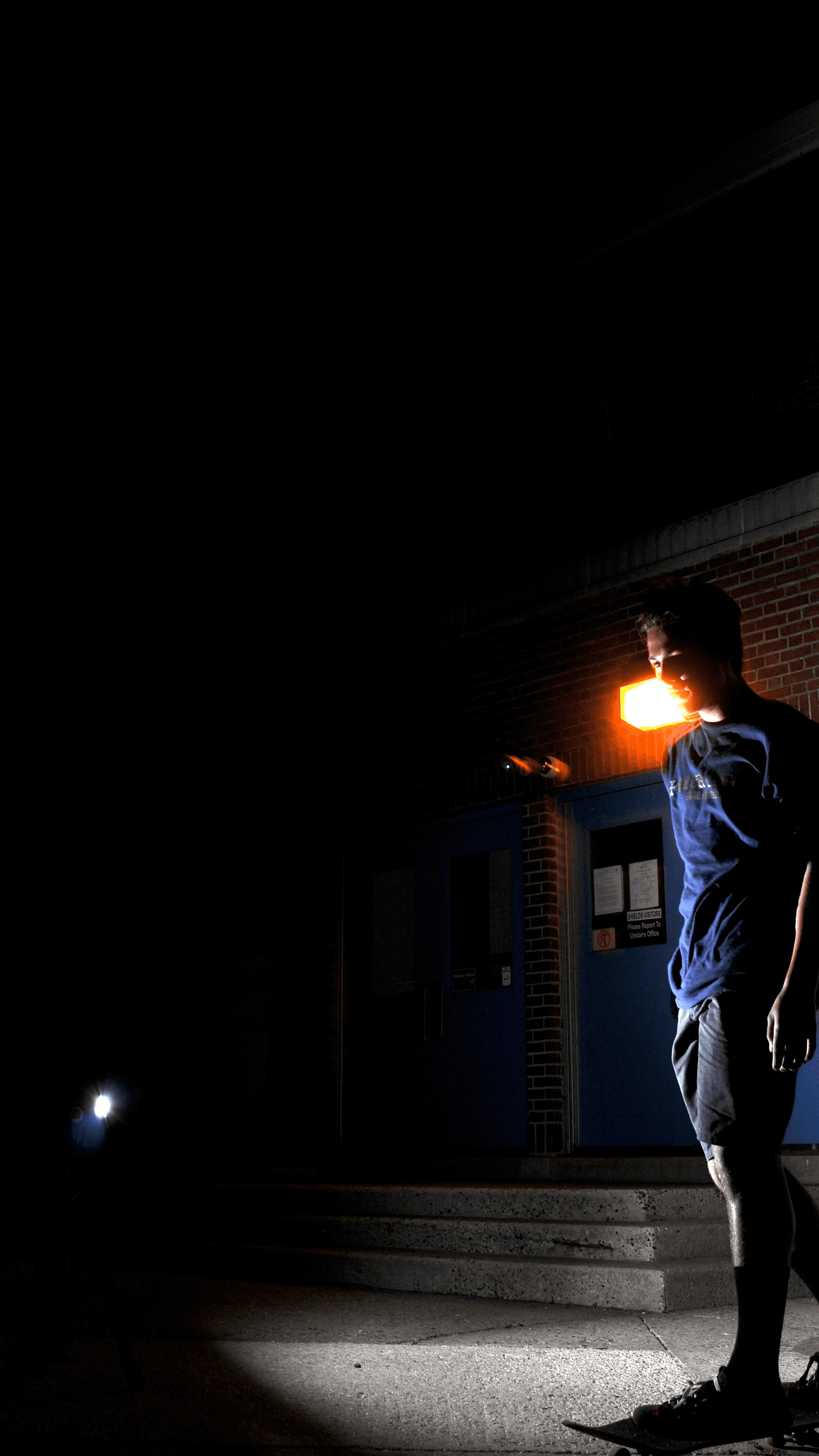 Digital photography of a skateboarder vaguely lit by a flash 