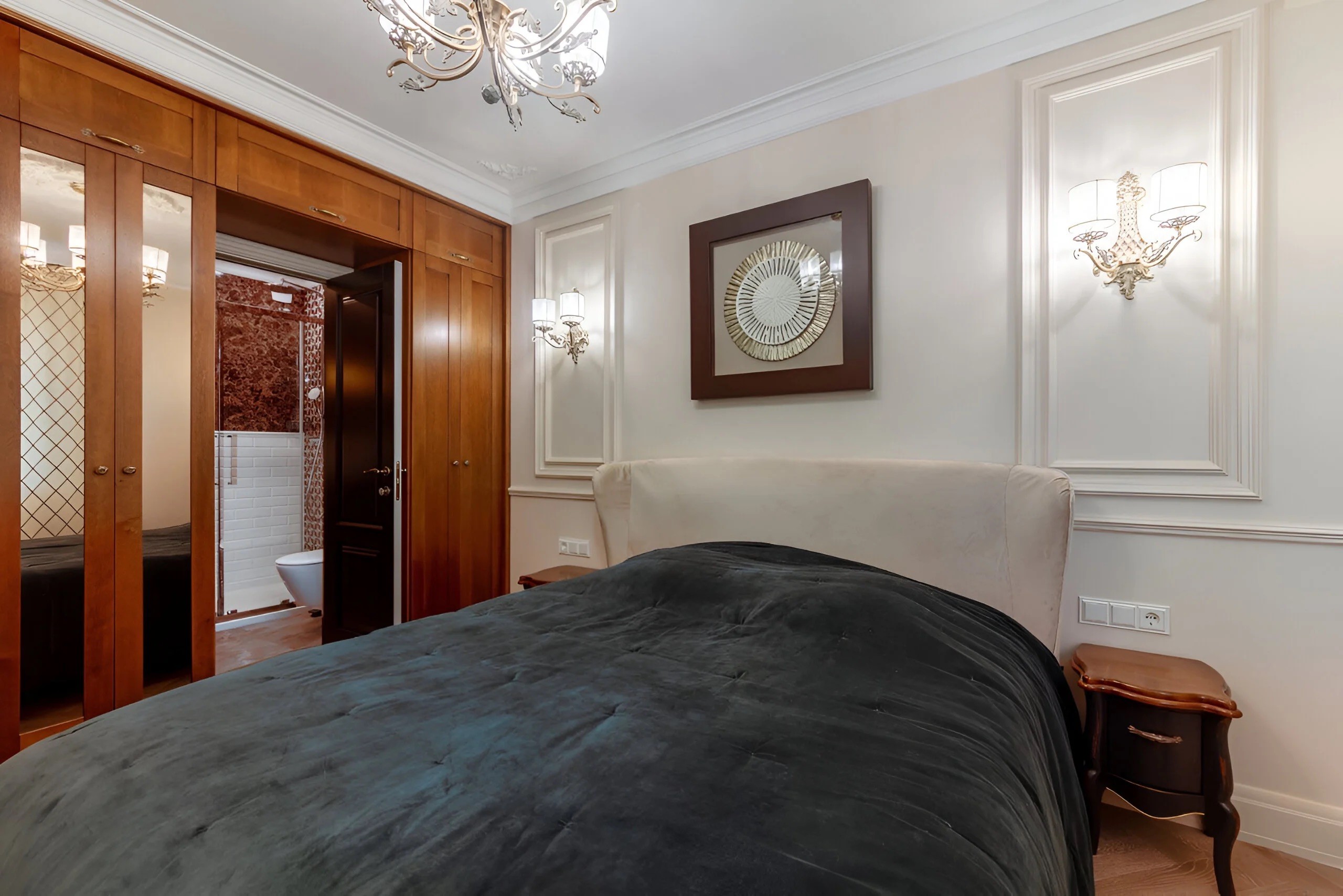 Dressing sur-mesure intégré dans la chambre avec façades en bois noble et miroirs pour agrandir l'espace nuit.