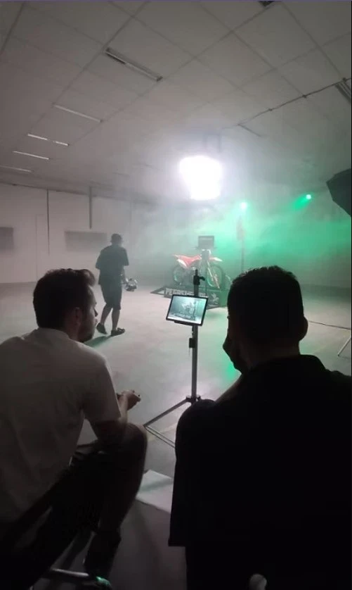 Set de filmagem com fumaça e luz verde e moto ao fundo, na gravação do produto Pegasus Pro