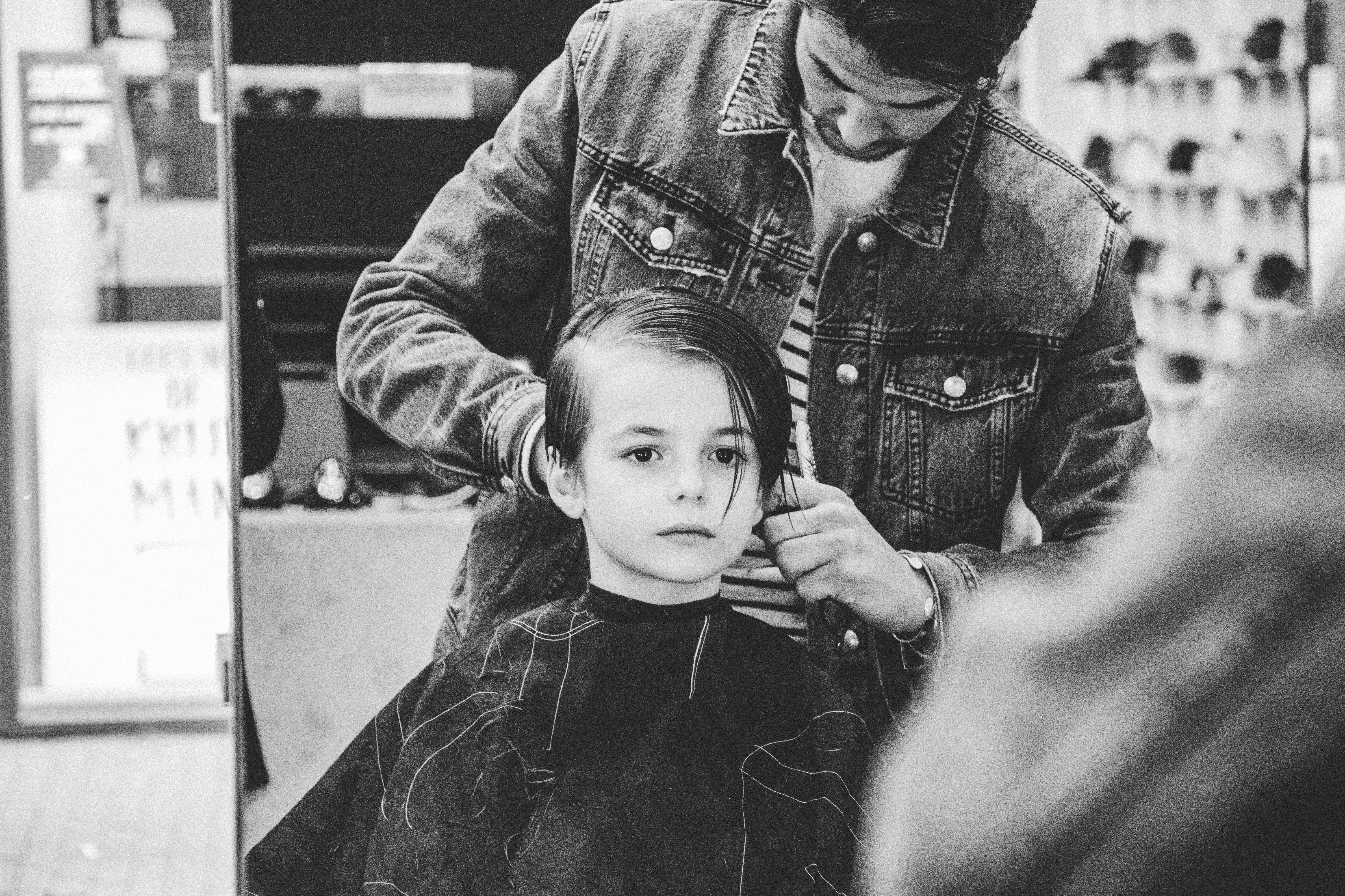 grayscale photography of man holding boys hair