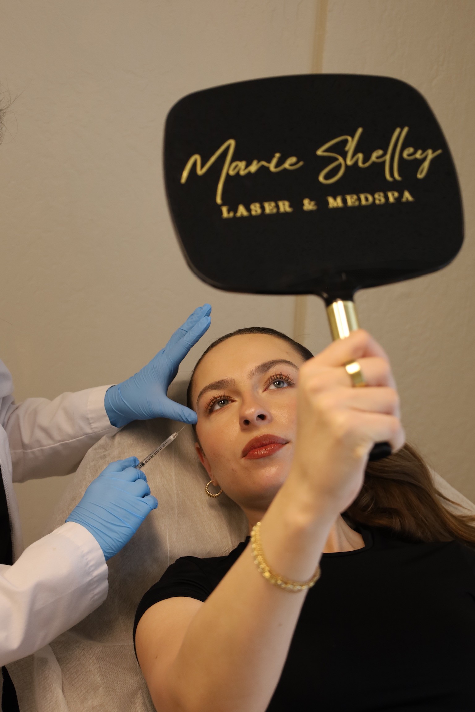 Marie Shelley Laser and Medspa Patient Holding a mirror