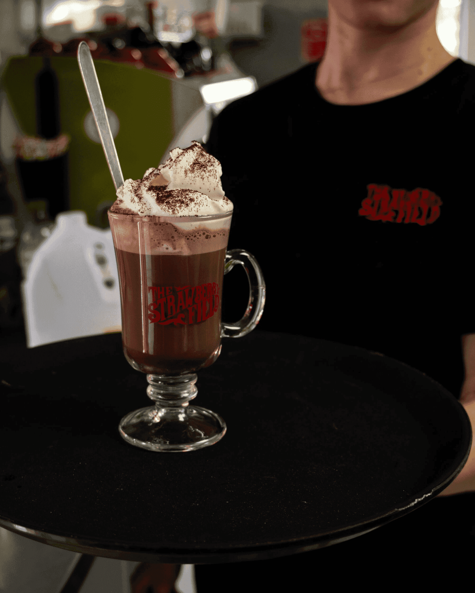 Server holding a tray with hot chocolate