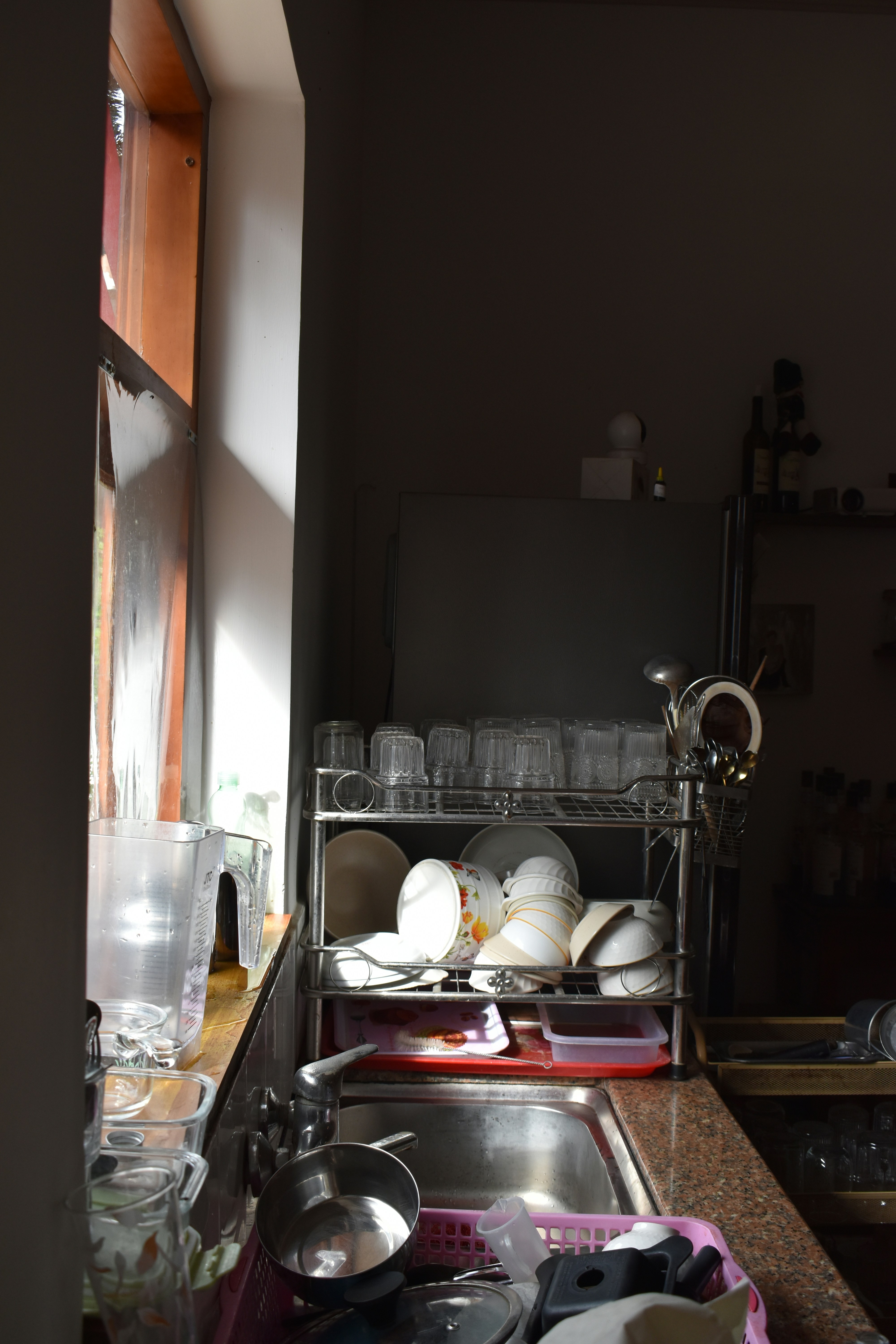 A kitchen filled with lots of clutter next to a window