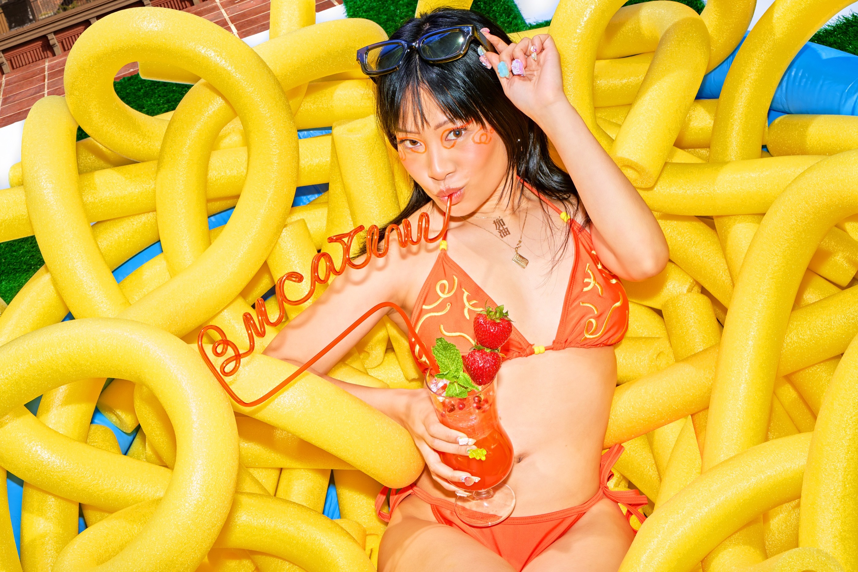 Wide portrait with the sculptural Bucakini sign and oversized noodles