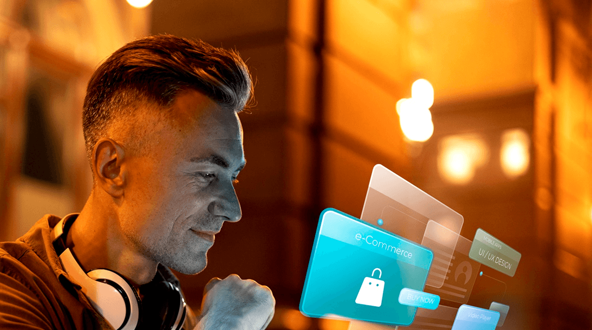 A man wearing headphones and a casual shirt is gazing thoughtfully at a glowing, holographic interface displaying icons of a shopping cart, applications, and digital communications against a modern, warmly lit background.
