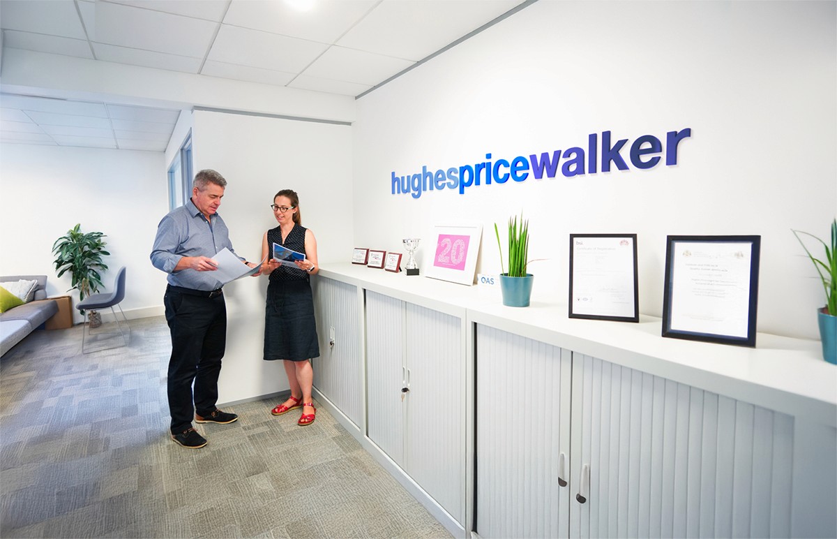 Hughes Price Walker office reception with team members reviewing pension scheme documents.