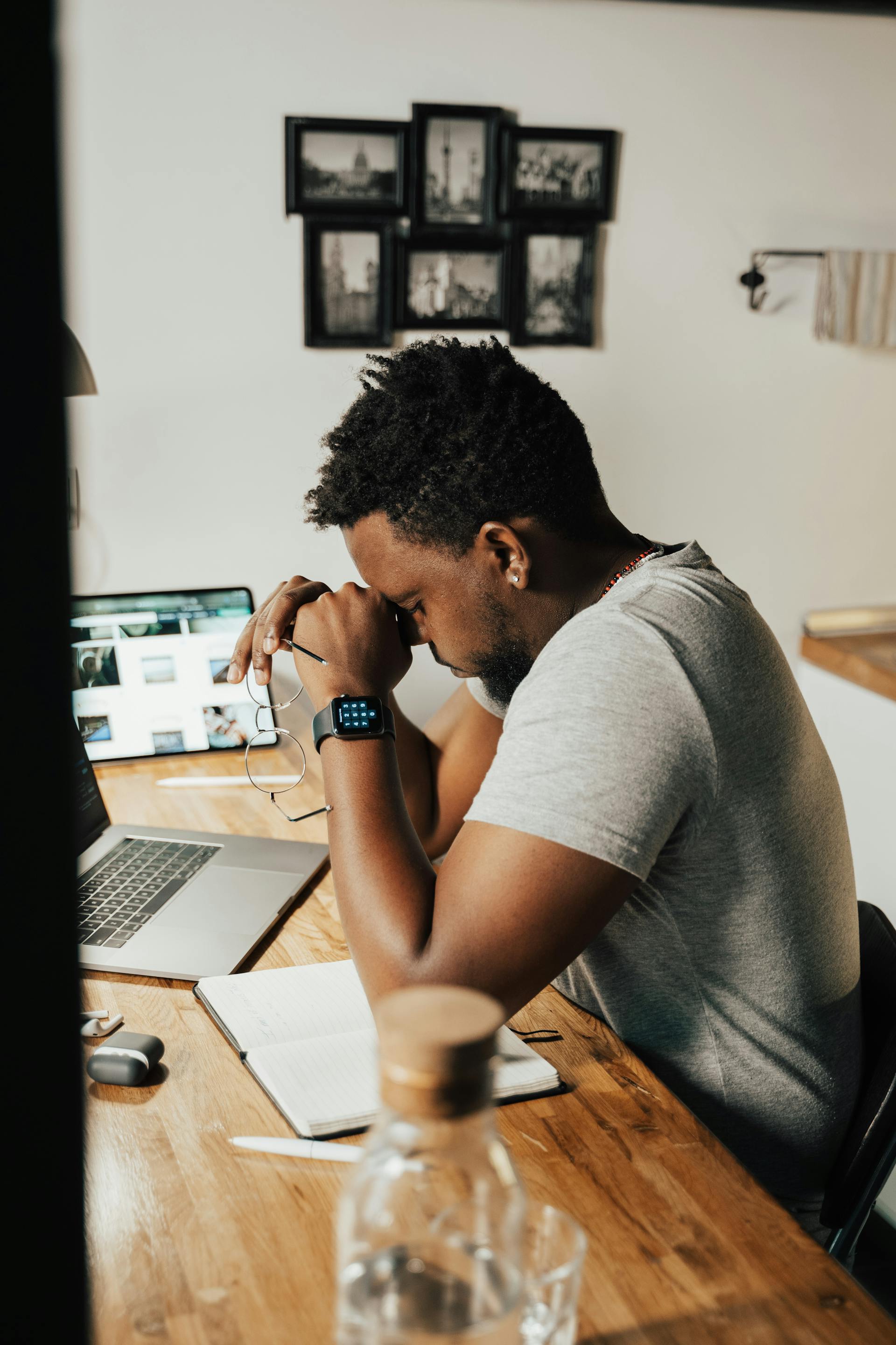 Man sitting at desk with head in hands, feeling exhausted from work burnout