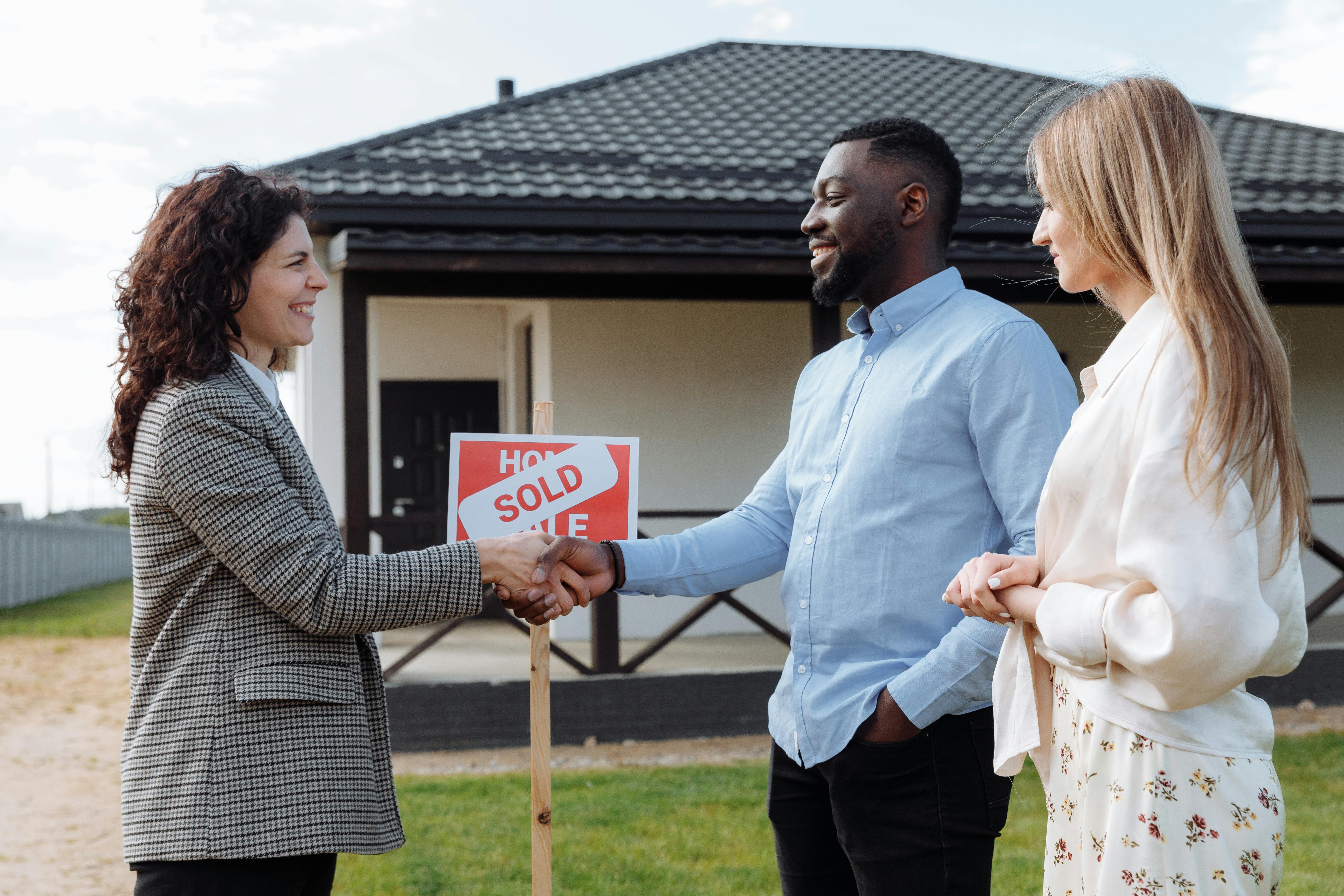 A couple shaking hands with a property agent