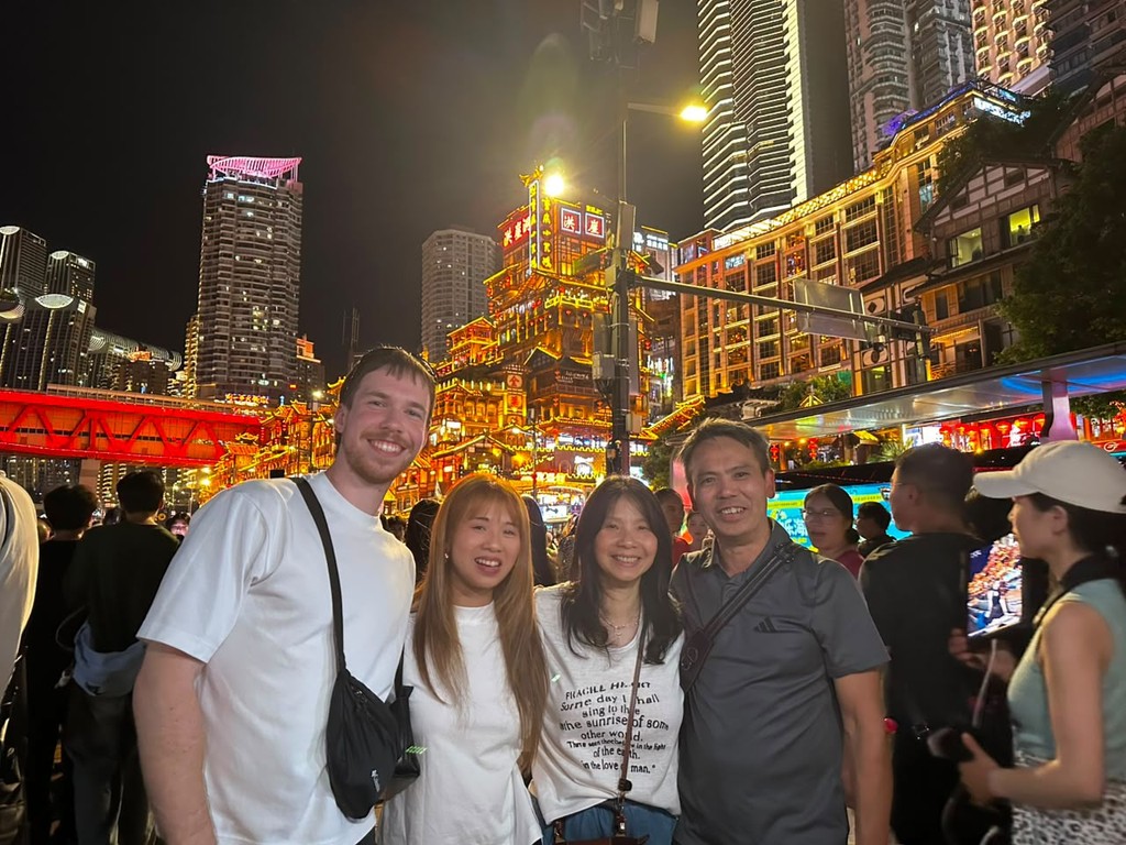 A small group of travellers exploring a city at night