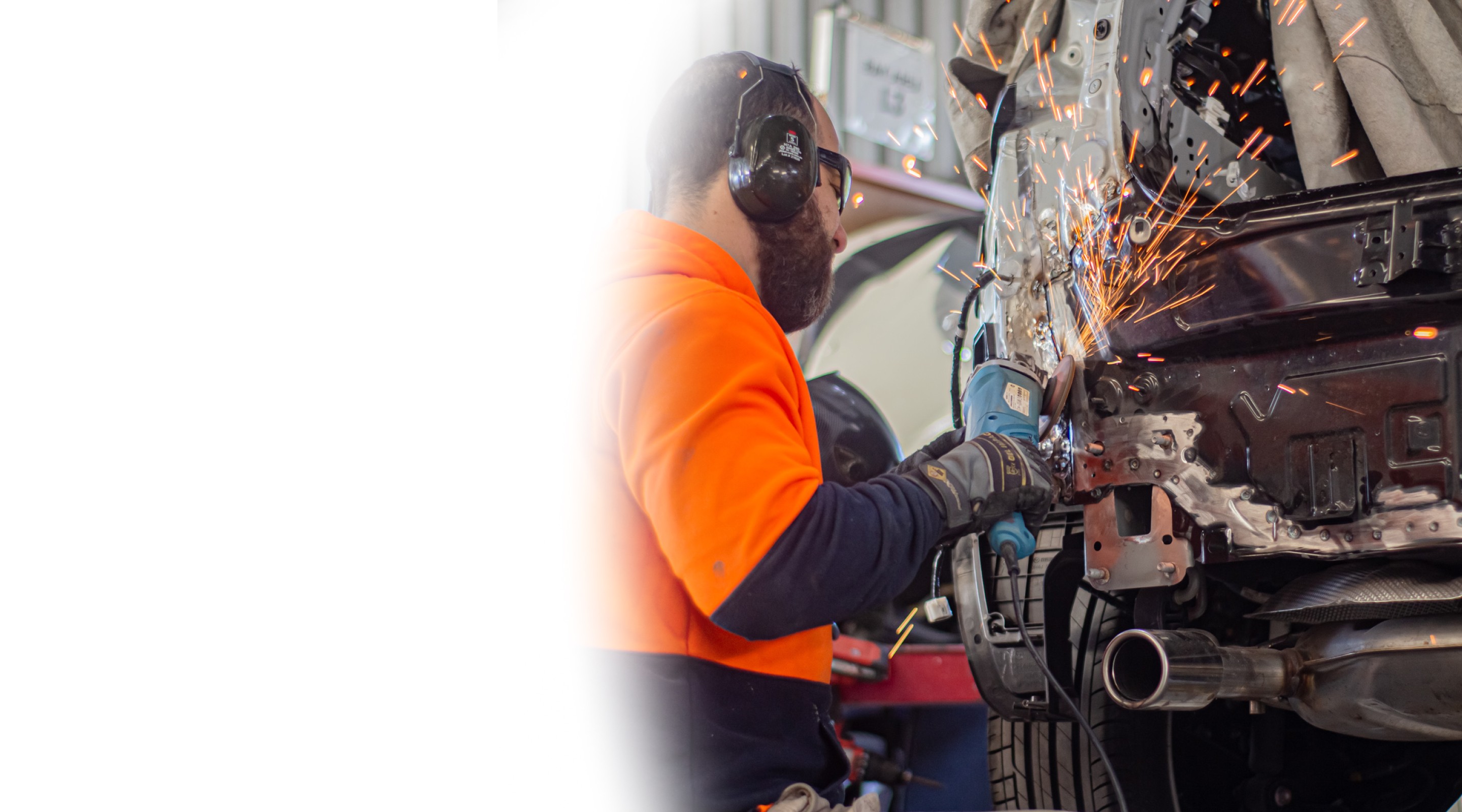Mechanic grinding car body, sparks flying