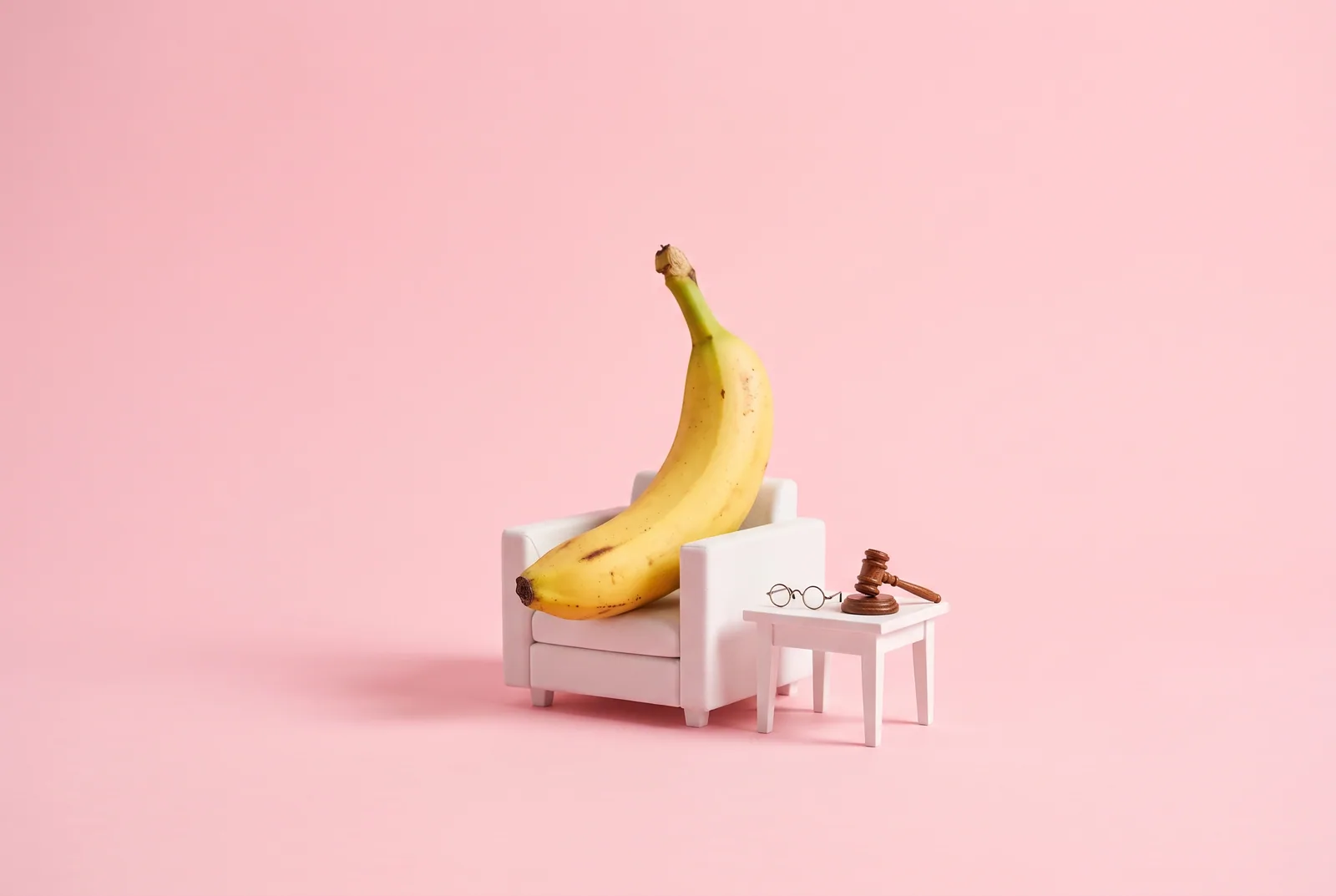 A banana in an armchair beside reading glasses and a gavel, a BlockerX review for QUITTR vs BlockerX