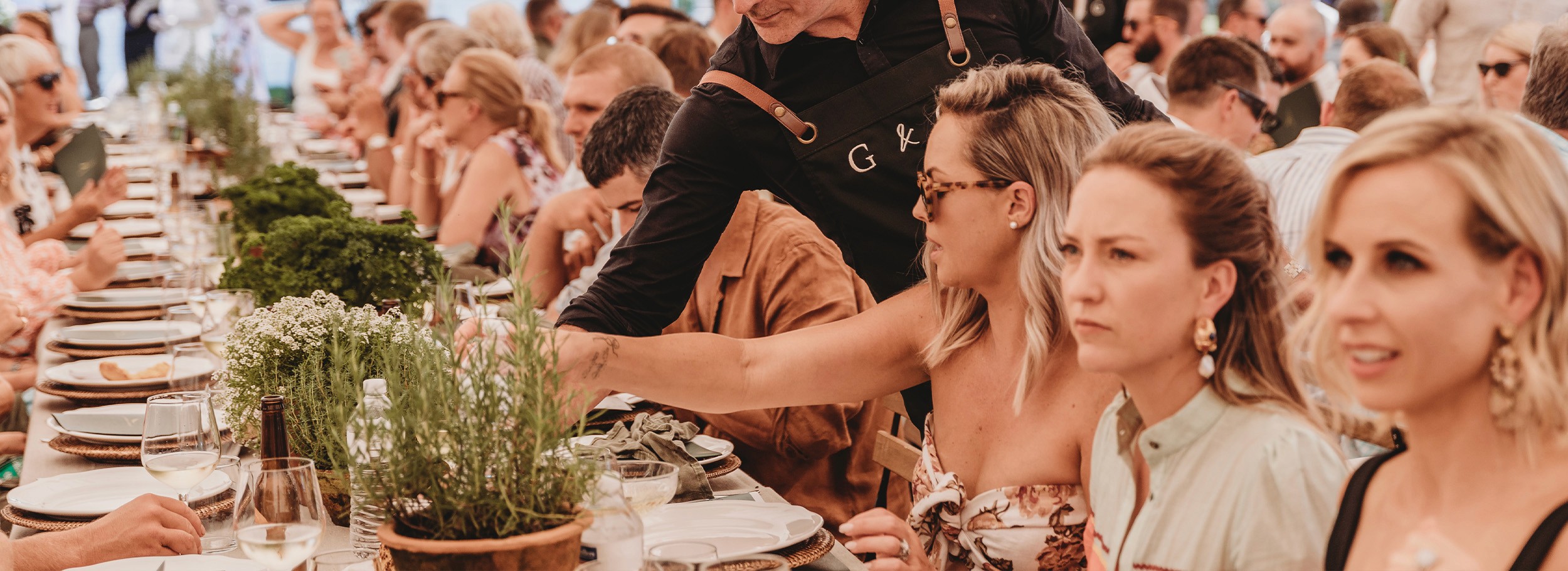 Waiter serving shared dining to seated guests