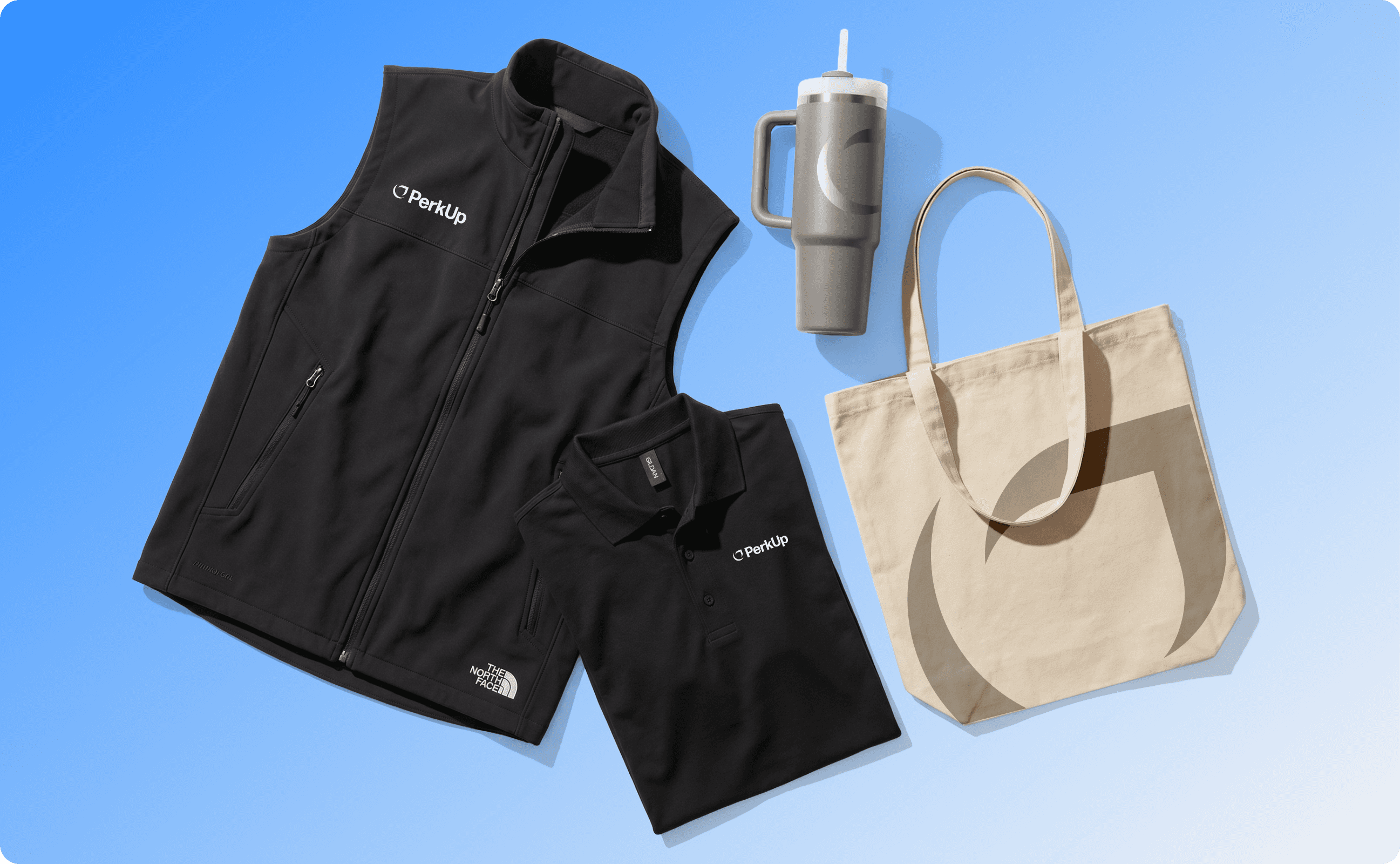 A black vest, a t-shirt, a Stanley tumbler, and a mesh tote bag.