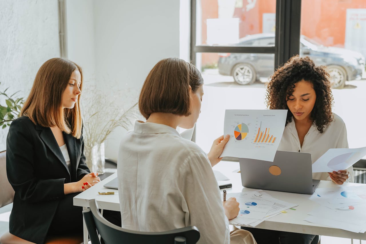Women in Long Sleeve Shirts Sitting at Table Working