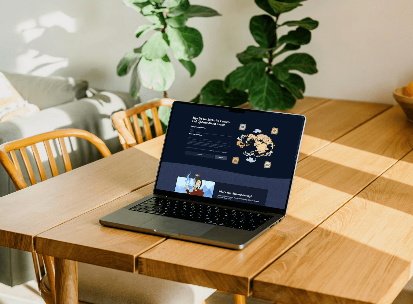 Fluid web design of a newsletter sign-up form and illustrated character card shown on a laptop in a sunlit room with wooden table and plants.