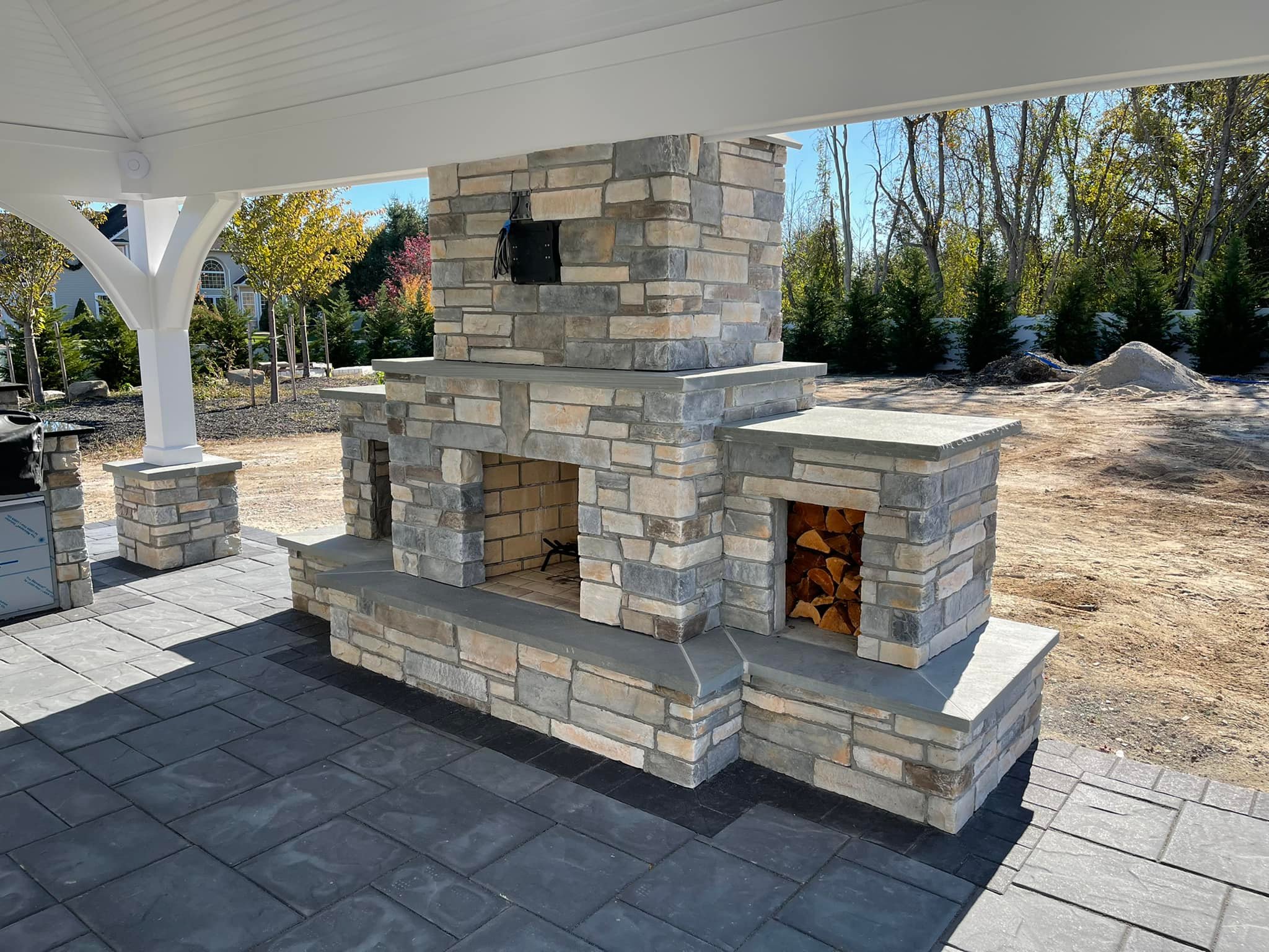 Multi-level stone patio with in-ground pool and curved seating walls