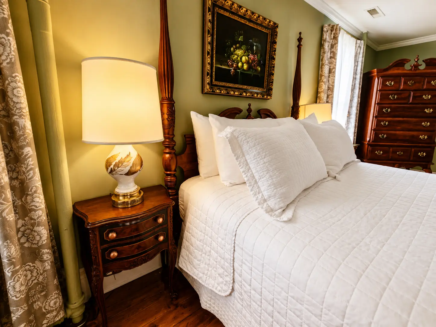 A cozy bedroom with a four-poster bed and a lit fireplace.