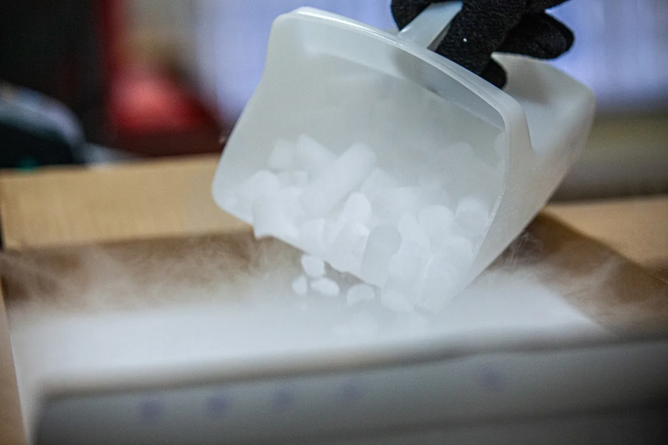Dry ice being scooped into an insulated shipping box