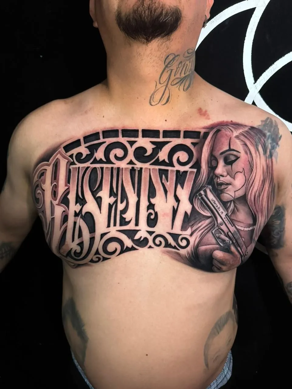 Black and grey Chicano chest tattoo with lettering and woman portrait at Calavera Ink Berlin
