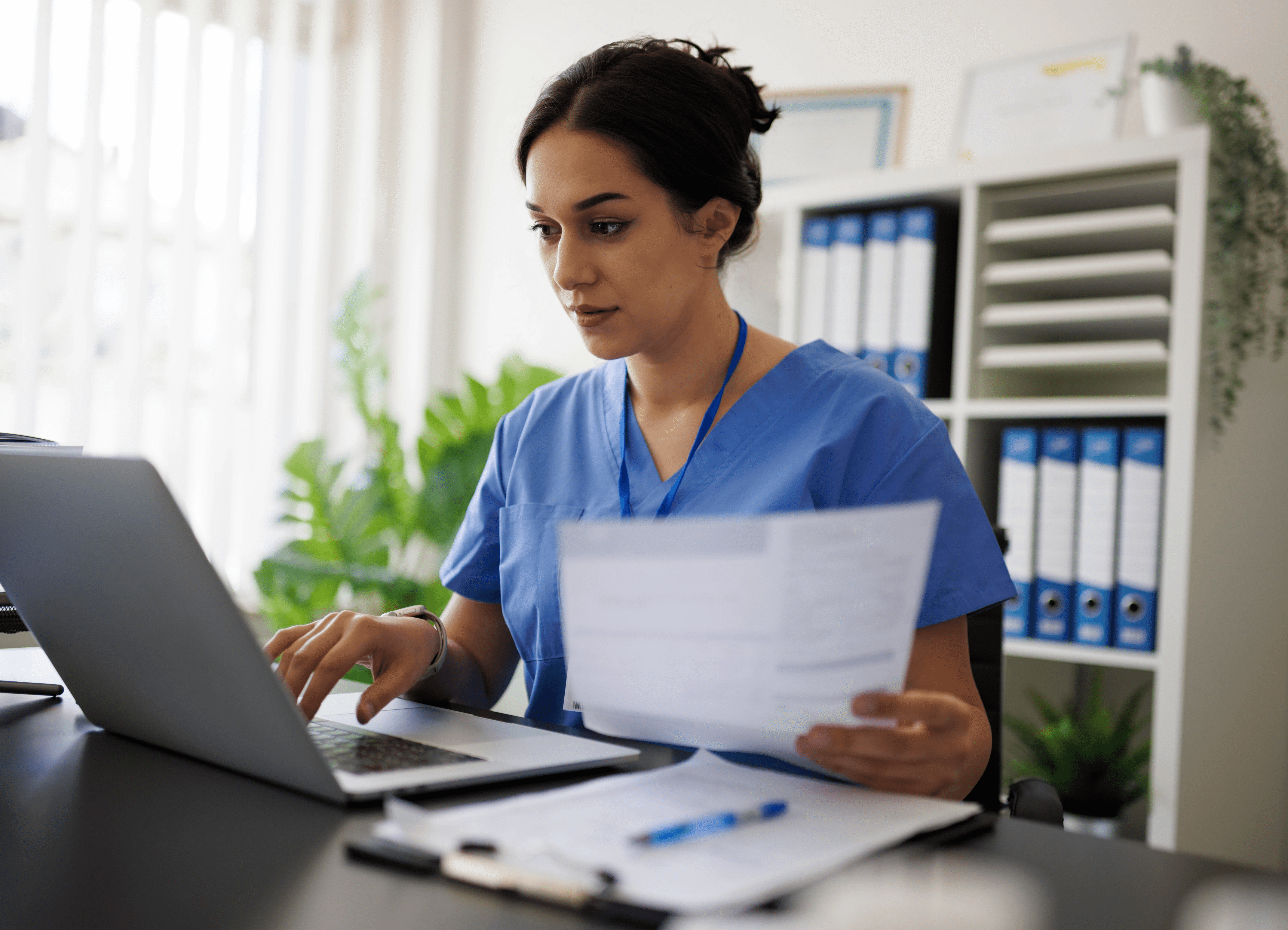 Person smiling while working on a laptop, with icons representing AI-powered research tools around