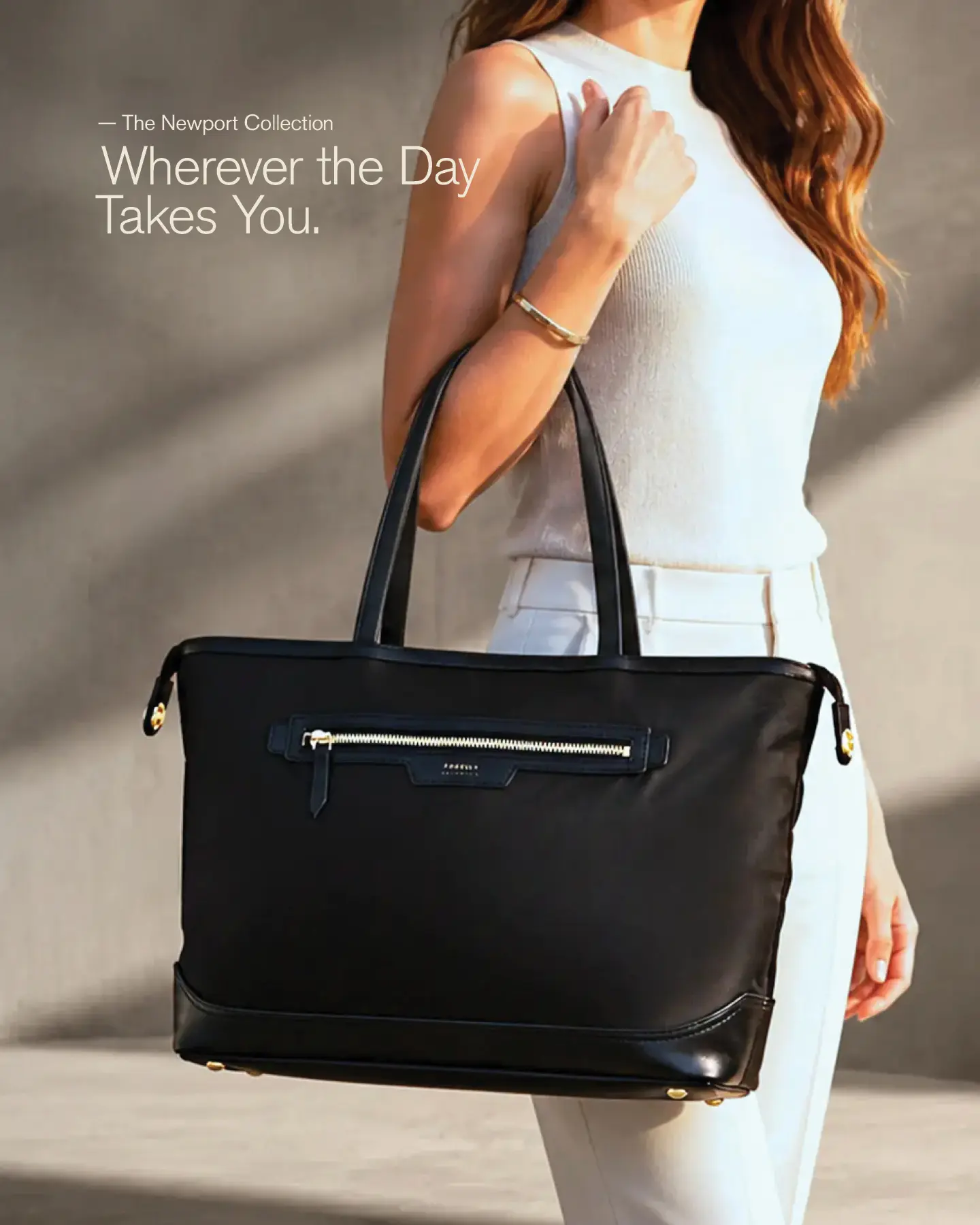 Woman carrying a black Newport tote in a modern architectural environment.