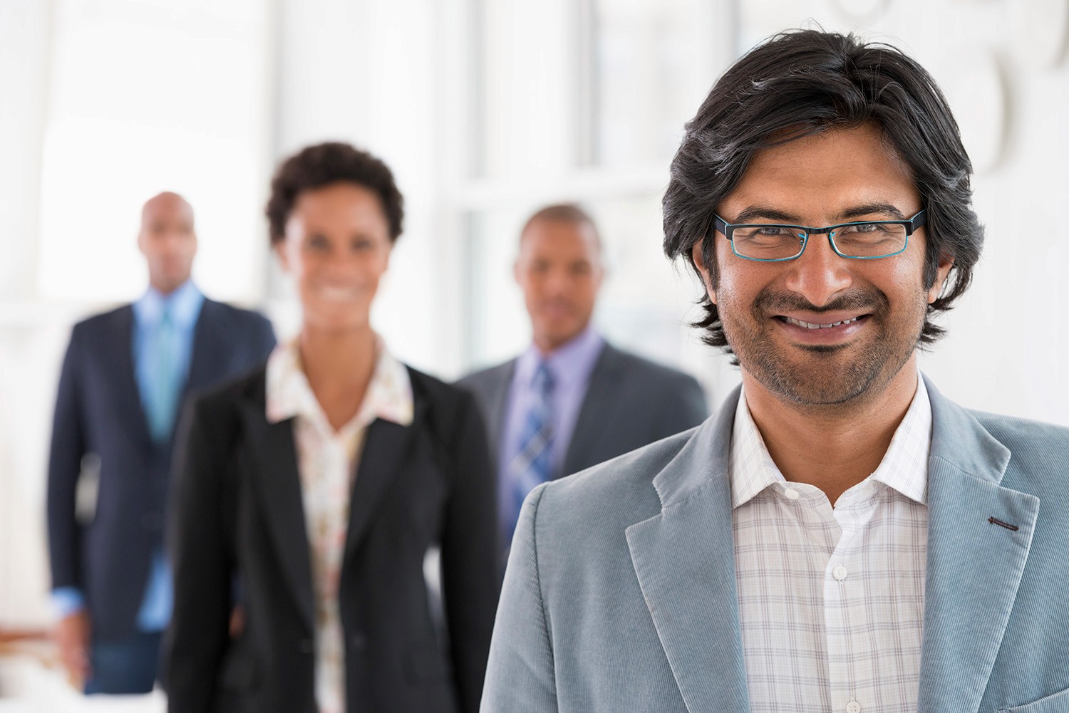 Happy business man with colleagues in background