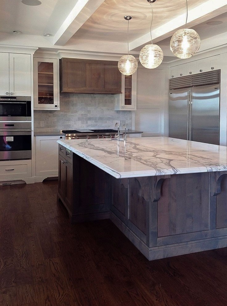 Image of Luxury kitchen interior design with marble island, stainless steel appliances, and custom cabinetry by KHD Homes.