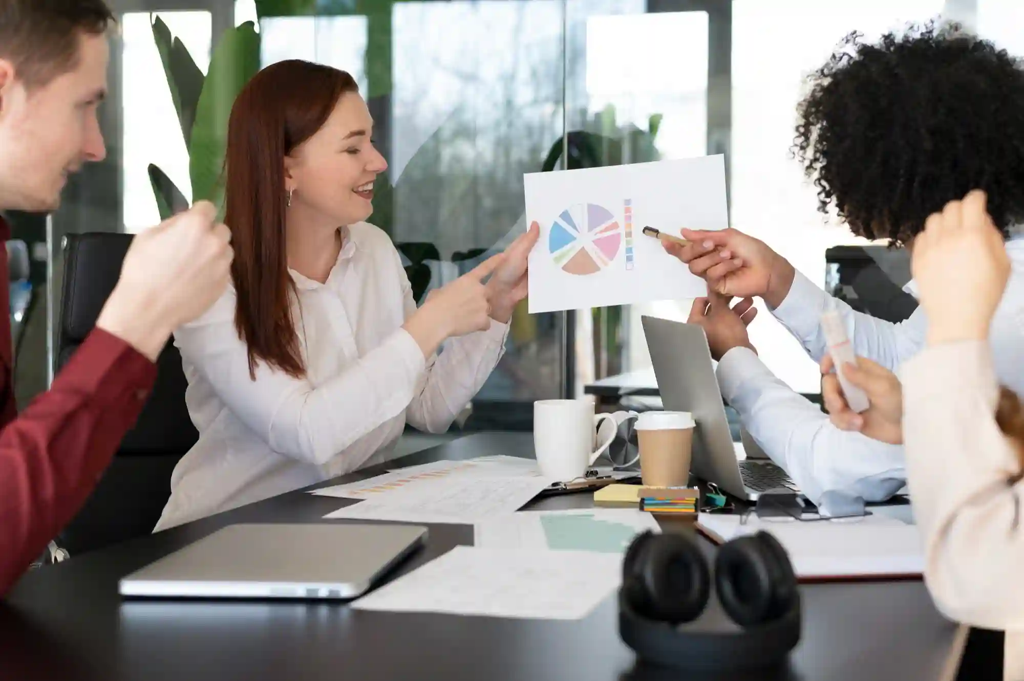 A team reviews a colorful pie chart in a meeting.