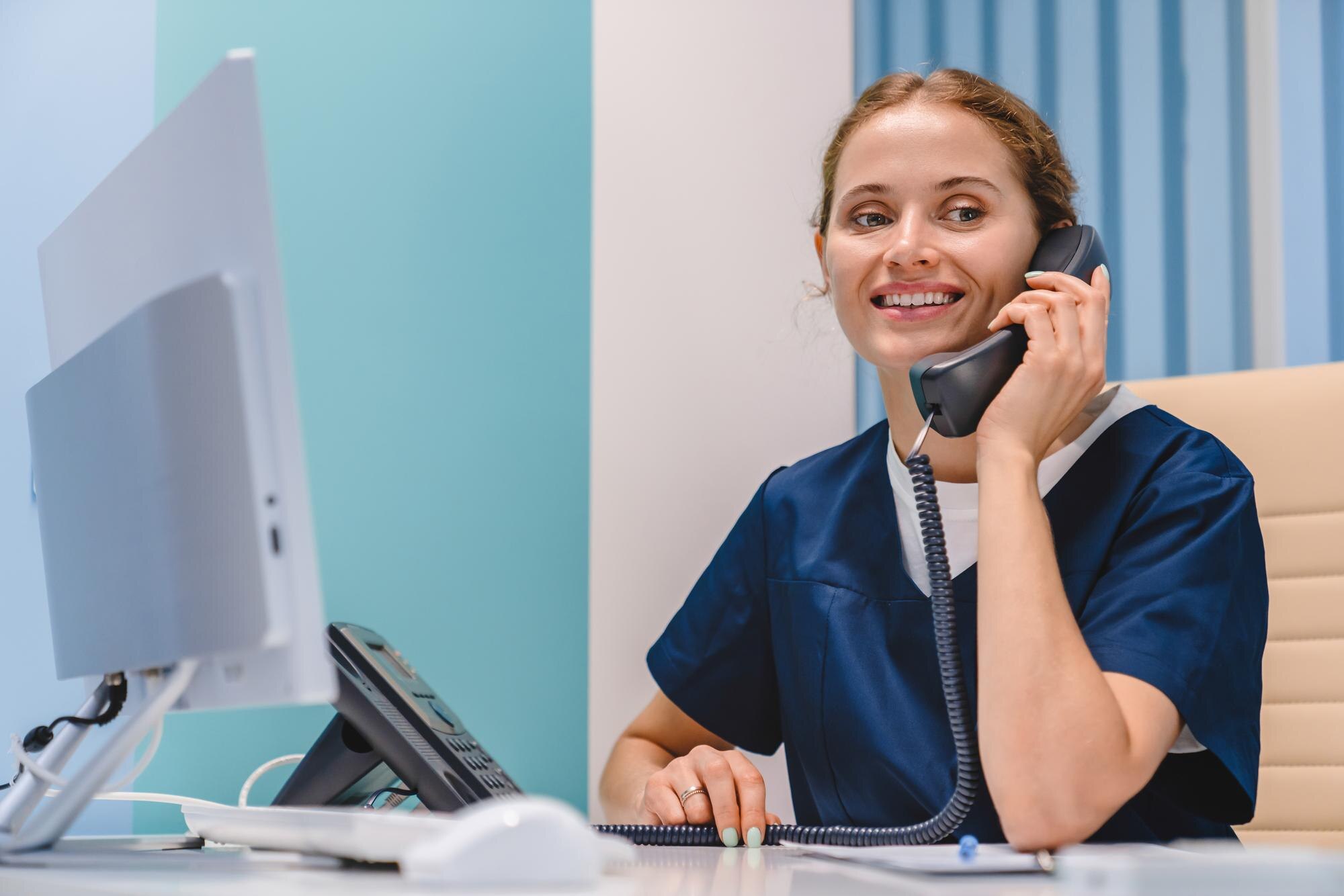 Receptioniste in een zorgpraktijk neemt de telefoon op, symbool voor AI-receptionist voor zorgpraktijken
