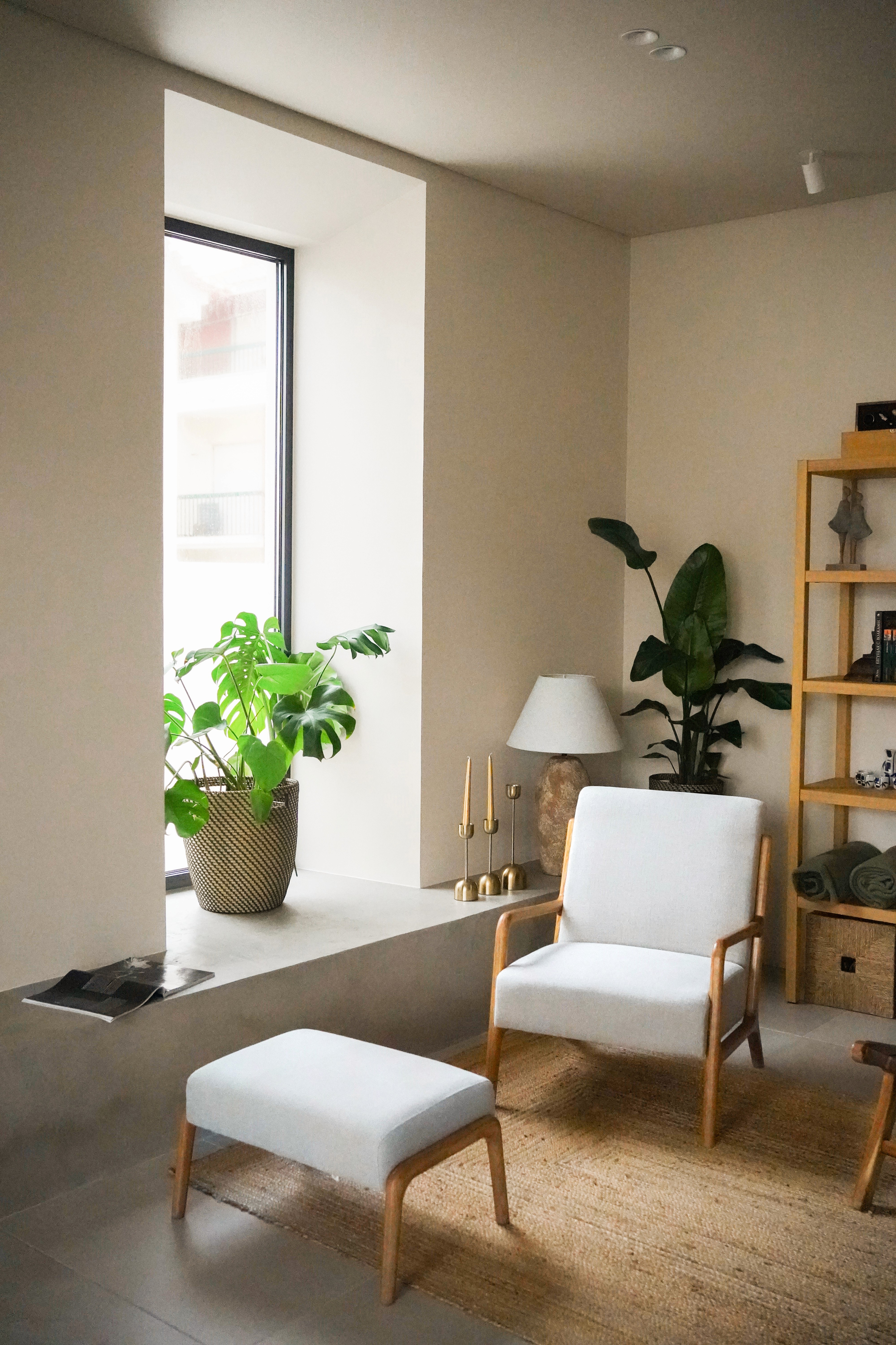 A sleek, green chair with a curved seat and wooden legs, set against a dark green background.