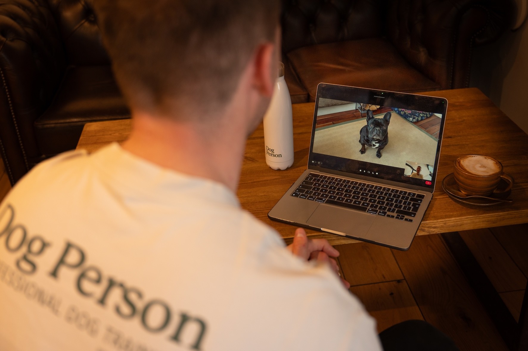 A laptop screen showing it is on a video call whilst training a dog.