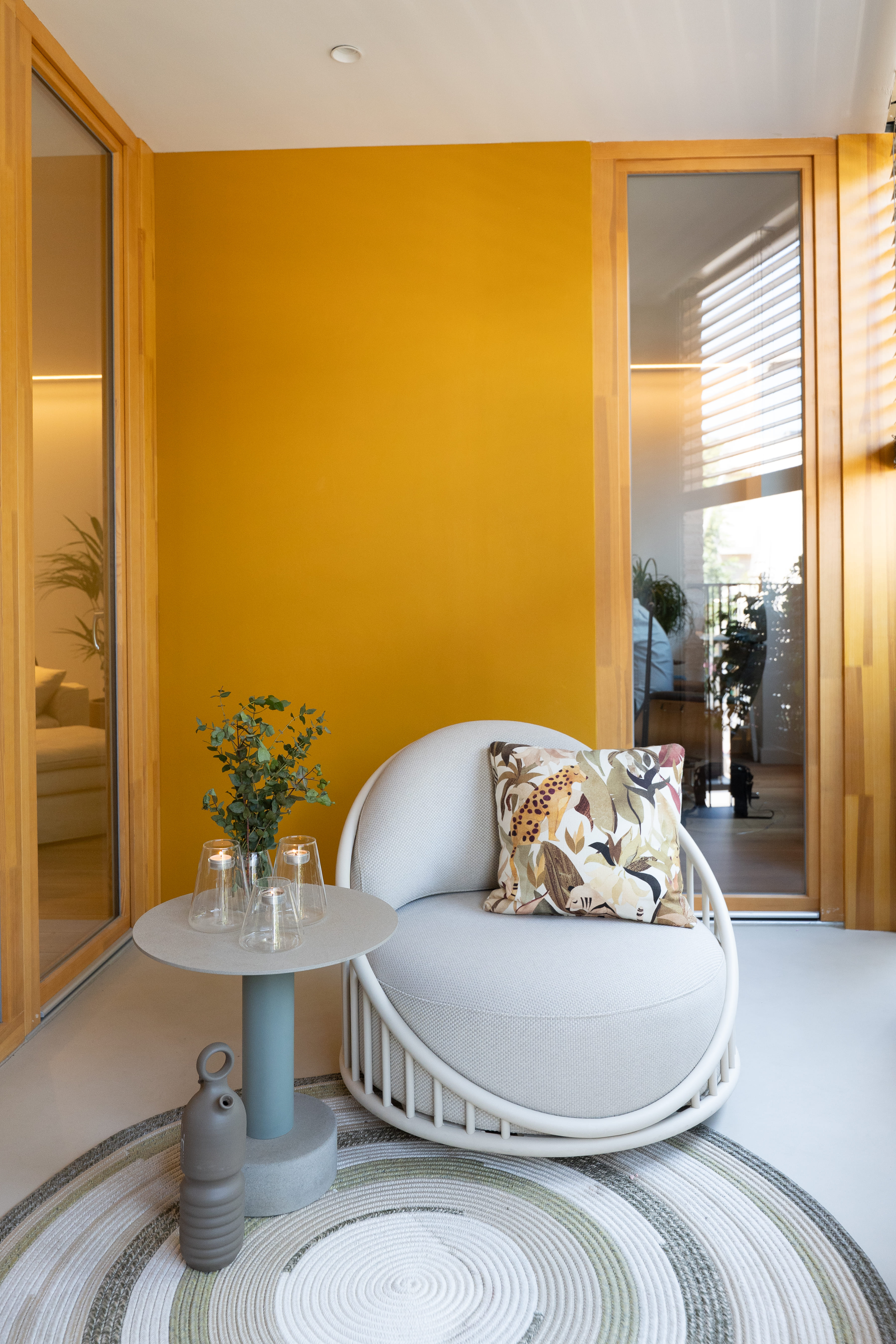 Sillón y mesa auxiliar en zona de terraza acristalada