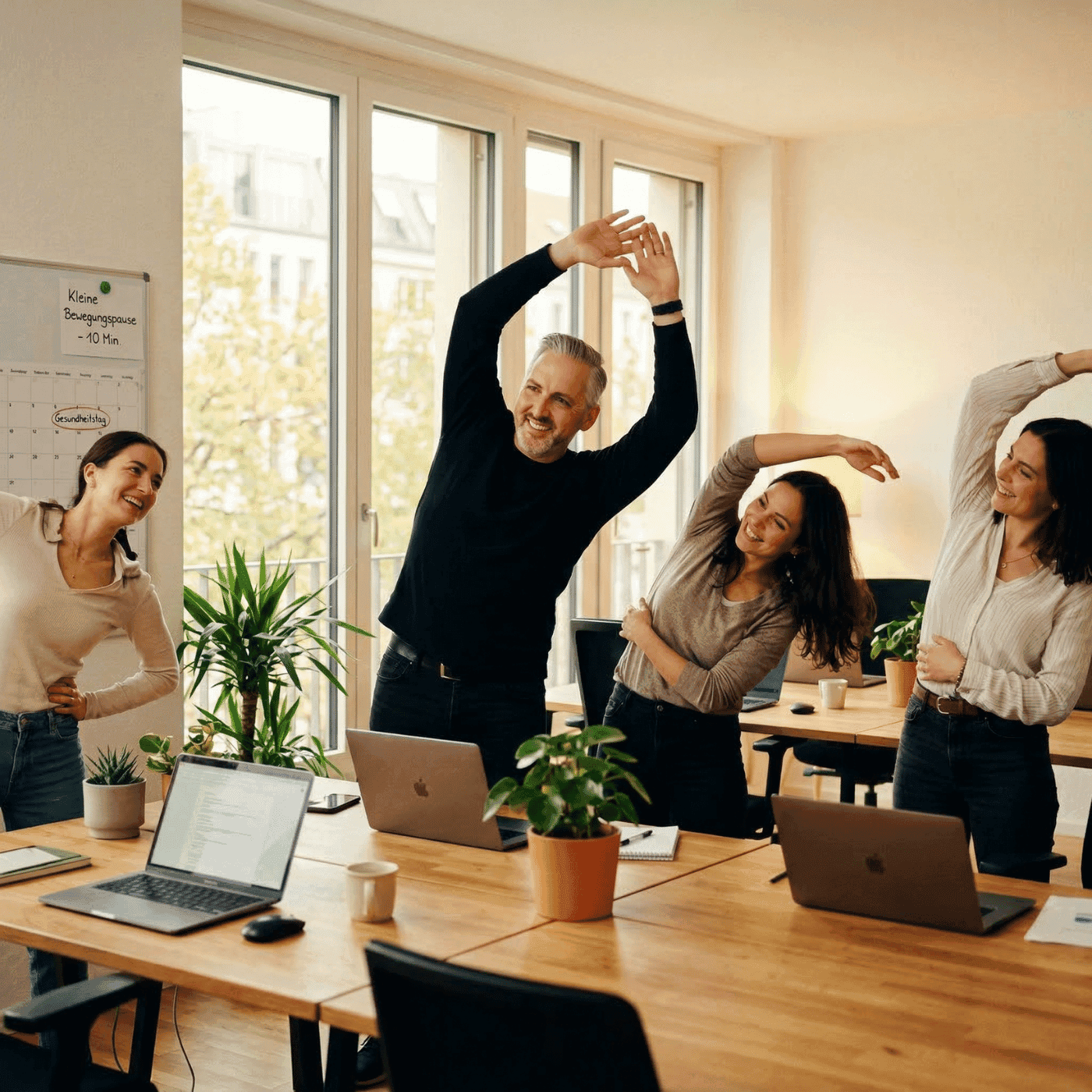 Team bei Bewegungspause im Büro — betriebliches Gesundheitsmanagement senkt Krankenstand nachhaltig
