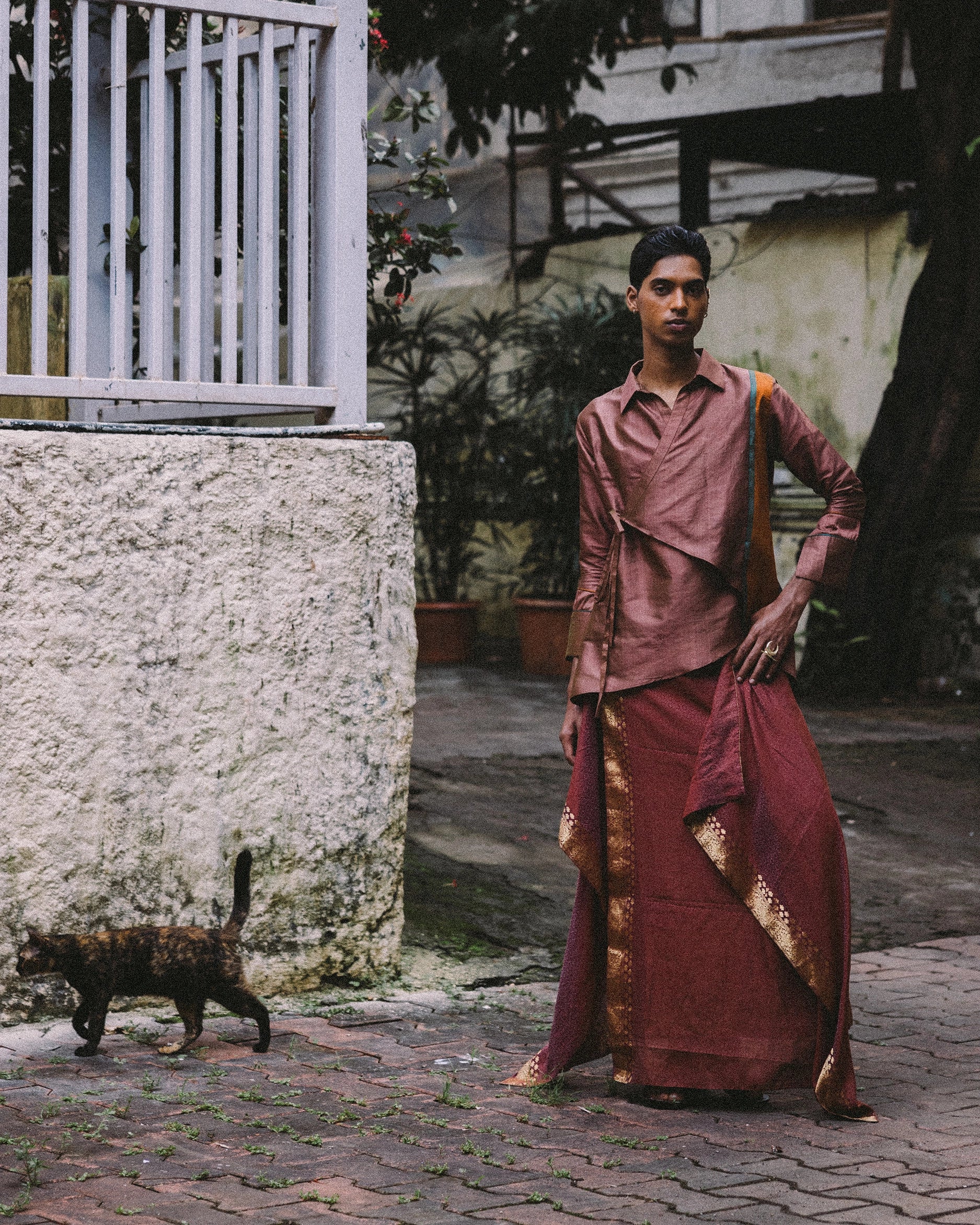 Rajasthani-inspired wrap top in rose silk blend with asymmetric hem and tie closures — modern reinterpretation of the traditional angrakha kurti